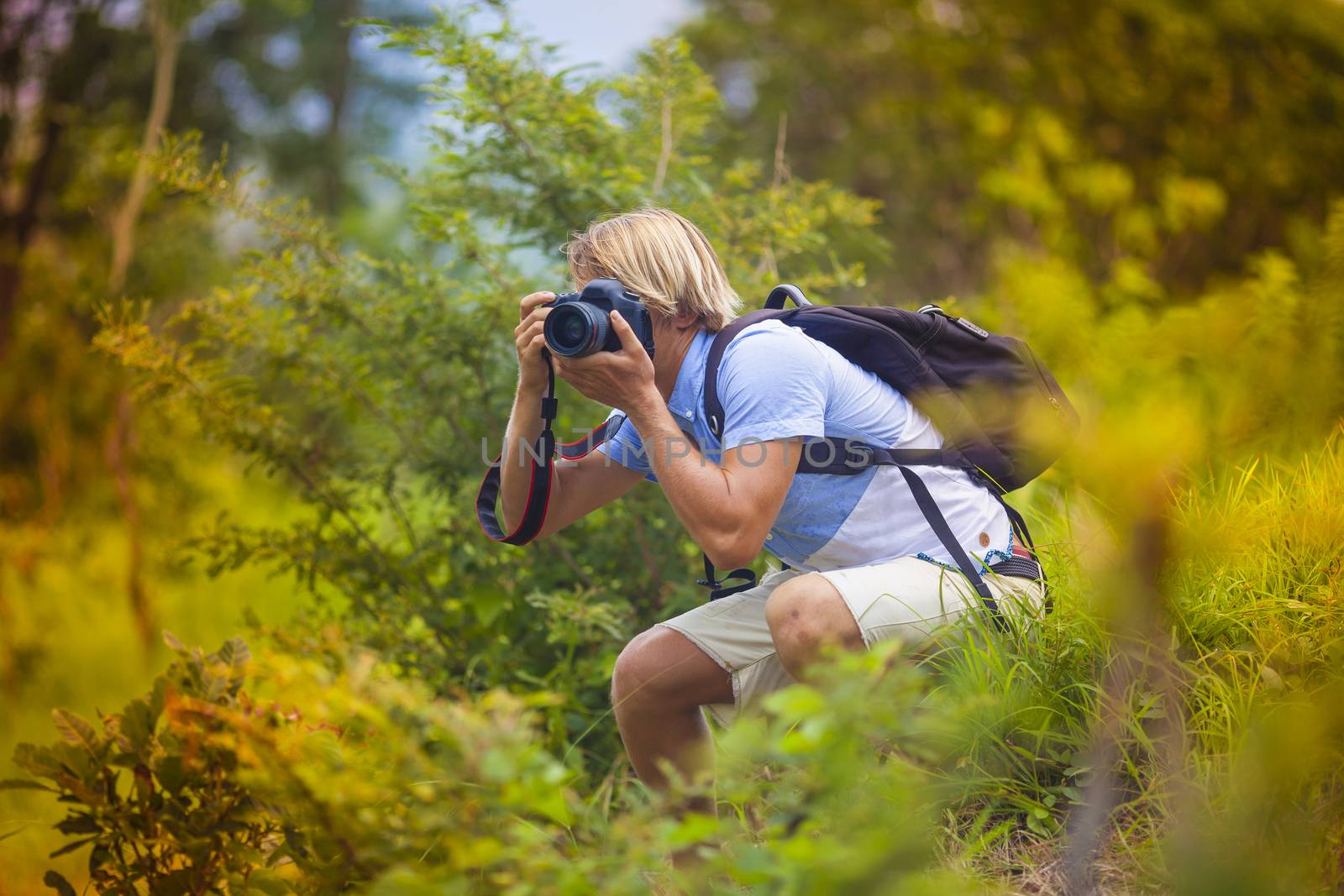 Photographer with Professional Digital Camera Taking Pictures in Nature