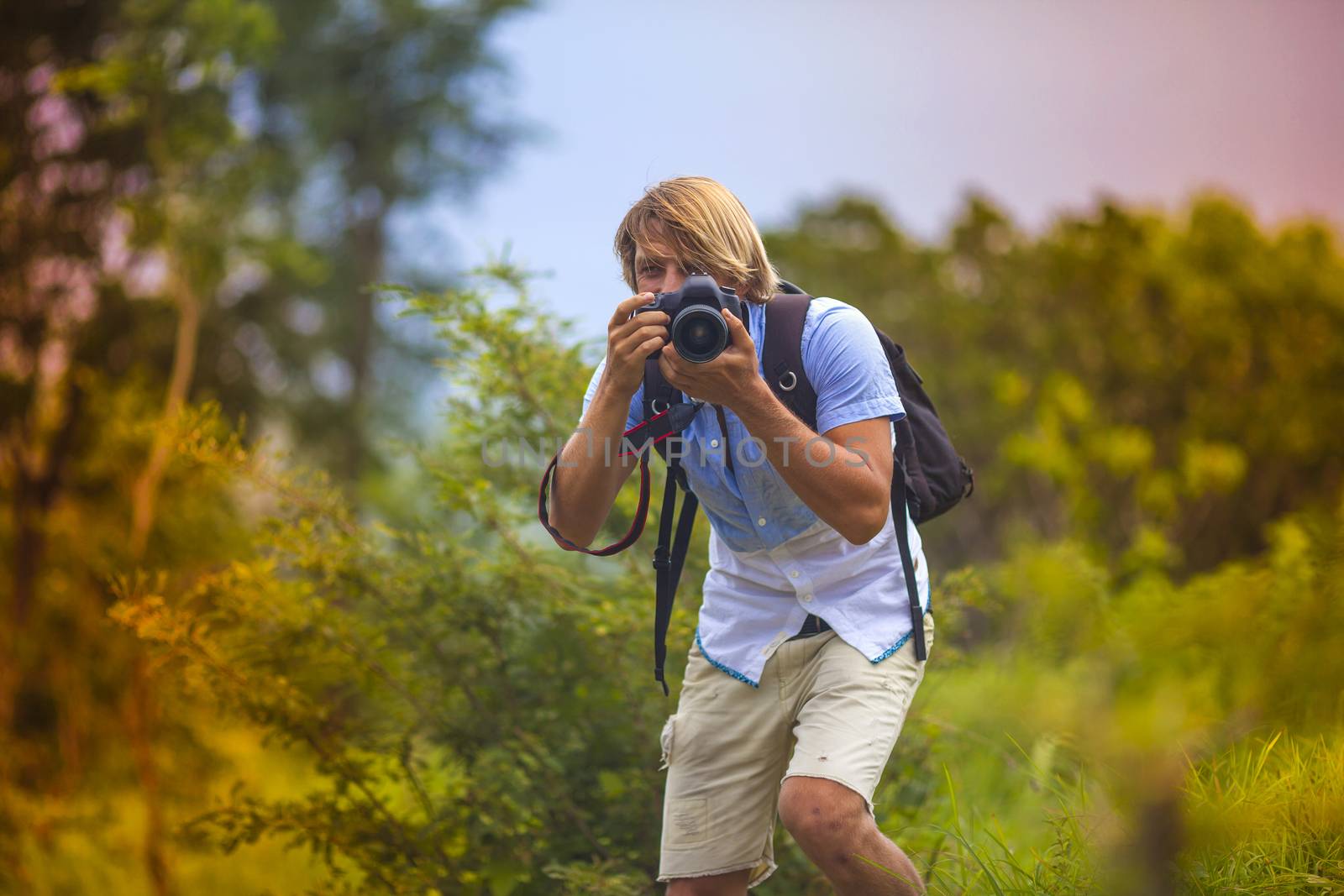 Photographer with Professional Digital Camera Taking Pictures in Nature