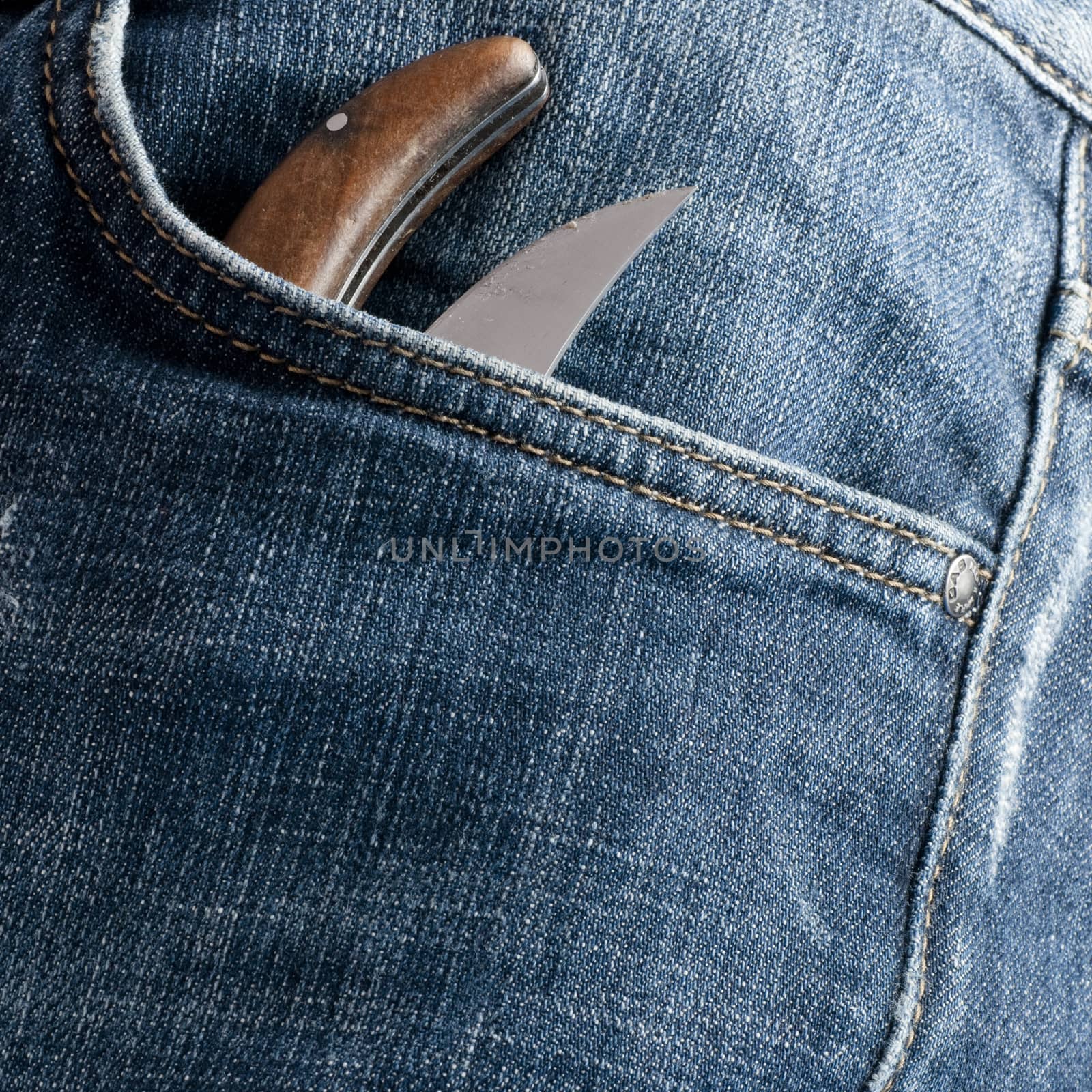 knife in the pocket in front of an old jeans