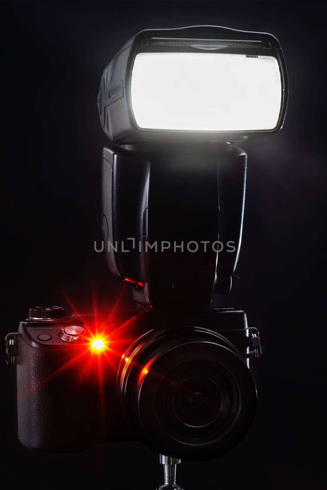black mirrorless camera with flash on black background