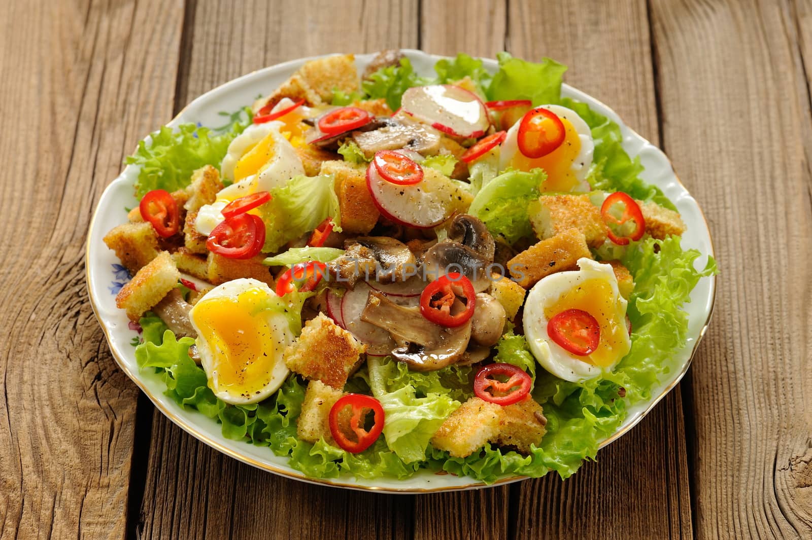 Salad Caesar with mushrooms, eggs, chili and radish on wooden ba by Borodin