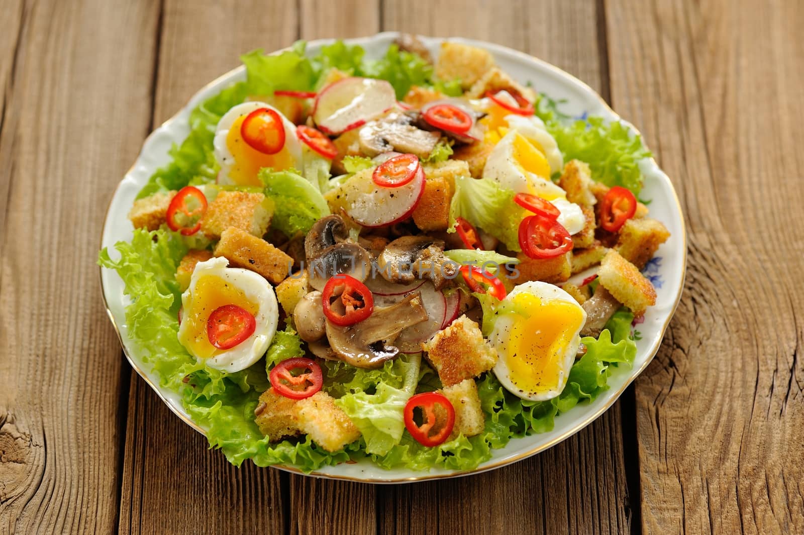 Salad Caesar with mushrooms, eggs, chili and radish on wooden ba by Borodin