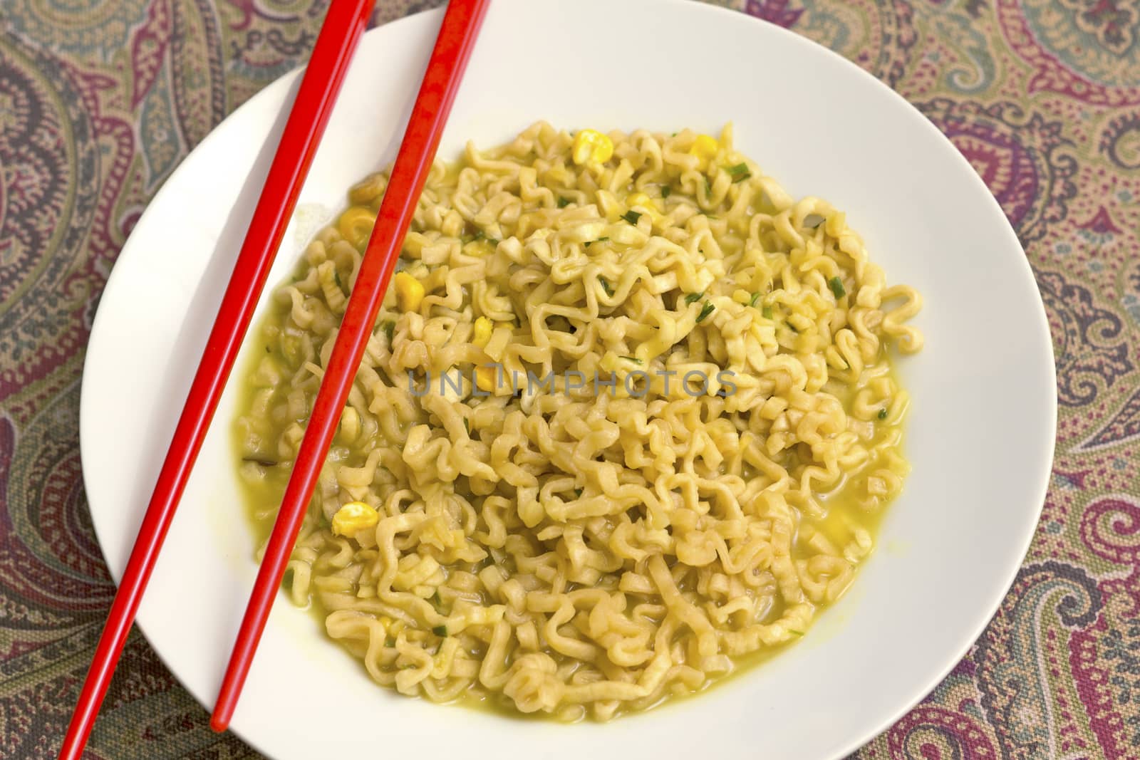 A dish of chicken noodles with red chopsticks