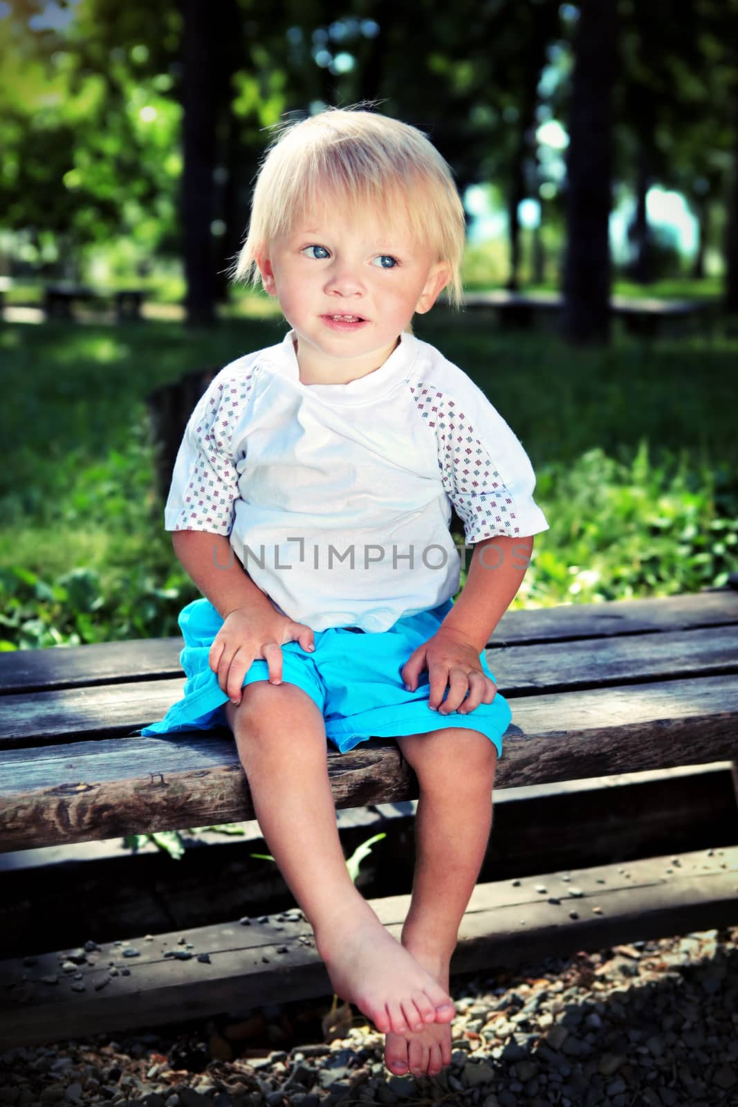 Vignetting Photo of the Child on the Bench at the Summer Park