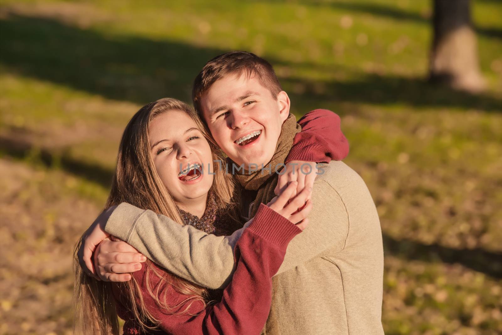 Laughing caucasian male and female couple embracing outdoors