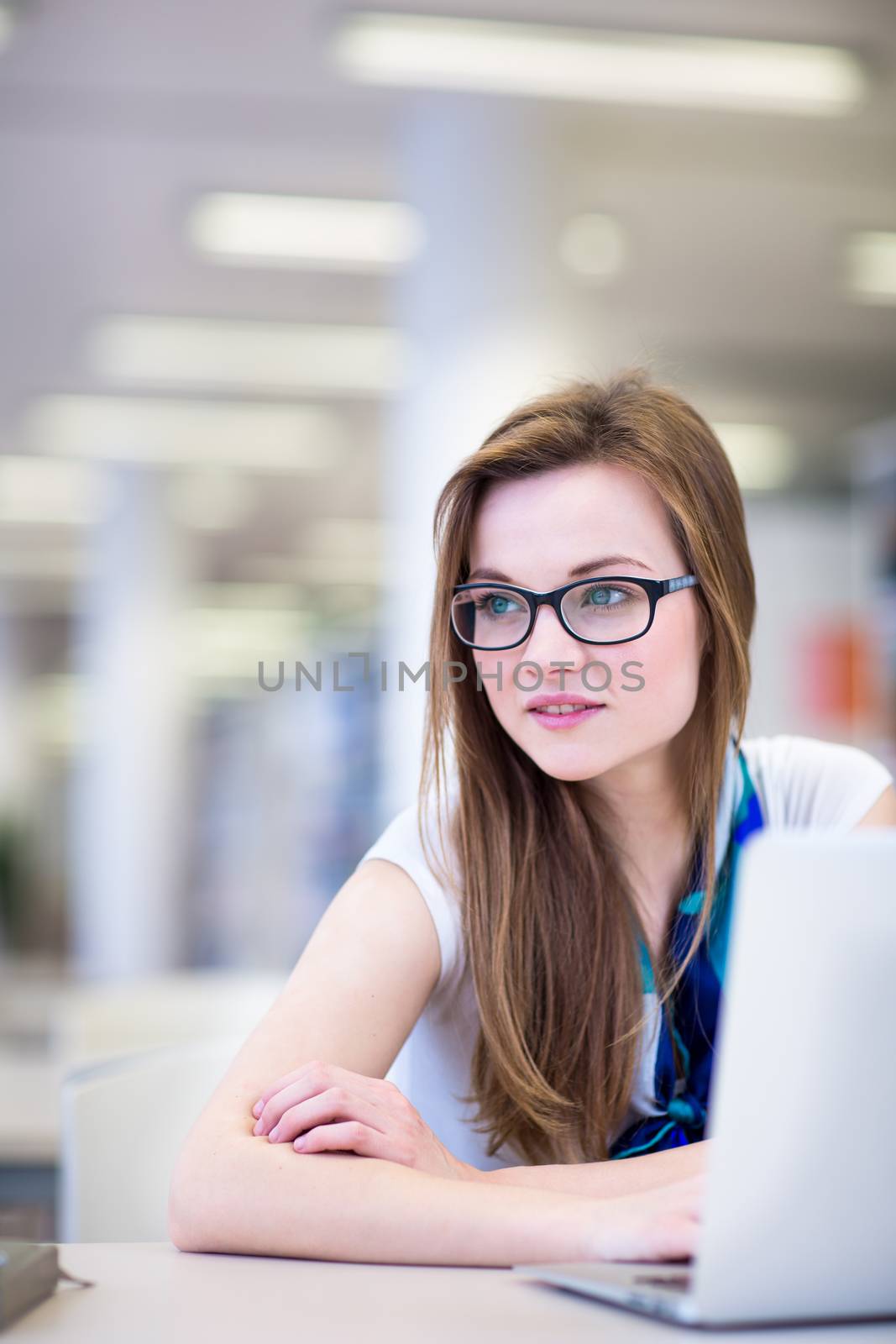 Pretty, female college student in a library, looking for a book  by viktor_cap