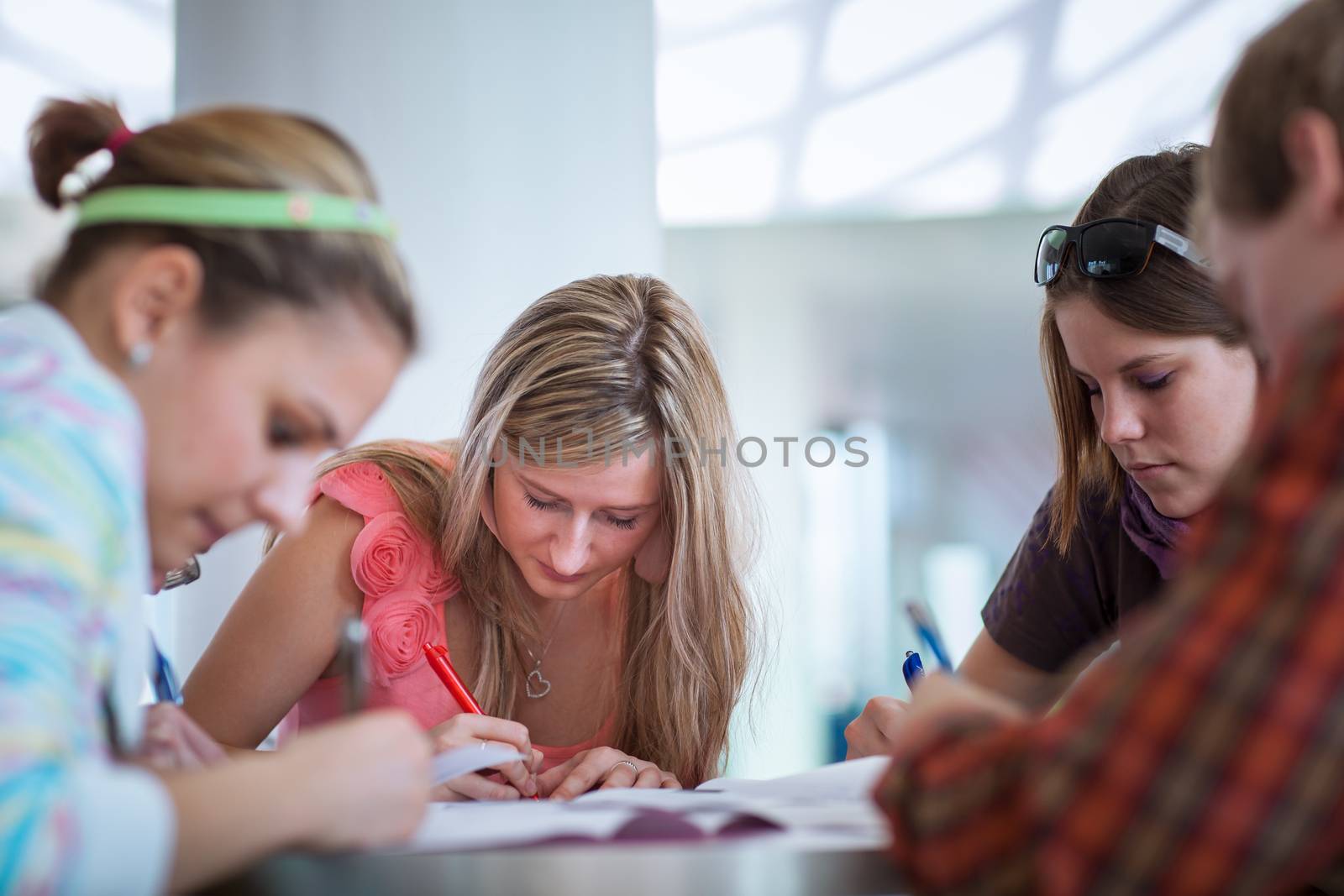 Group of college/university students during a brake between classes - chatting, comparing notes, having fun (shallow DOF; color toned image)