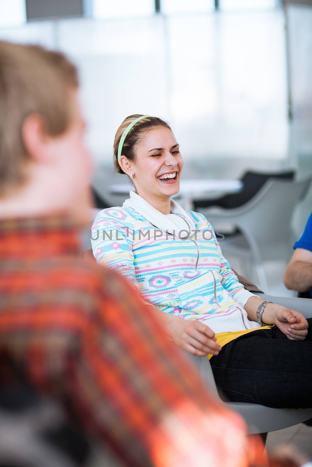 Group of college/university students during a brake between classes - chatting, comparing notes, having fun (shallow DOF; color toned image)