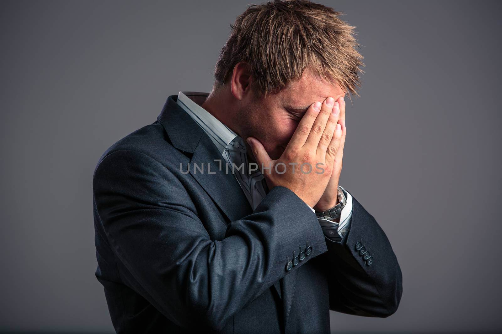 Businessman in depression with hands on forehead by viktor_cap