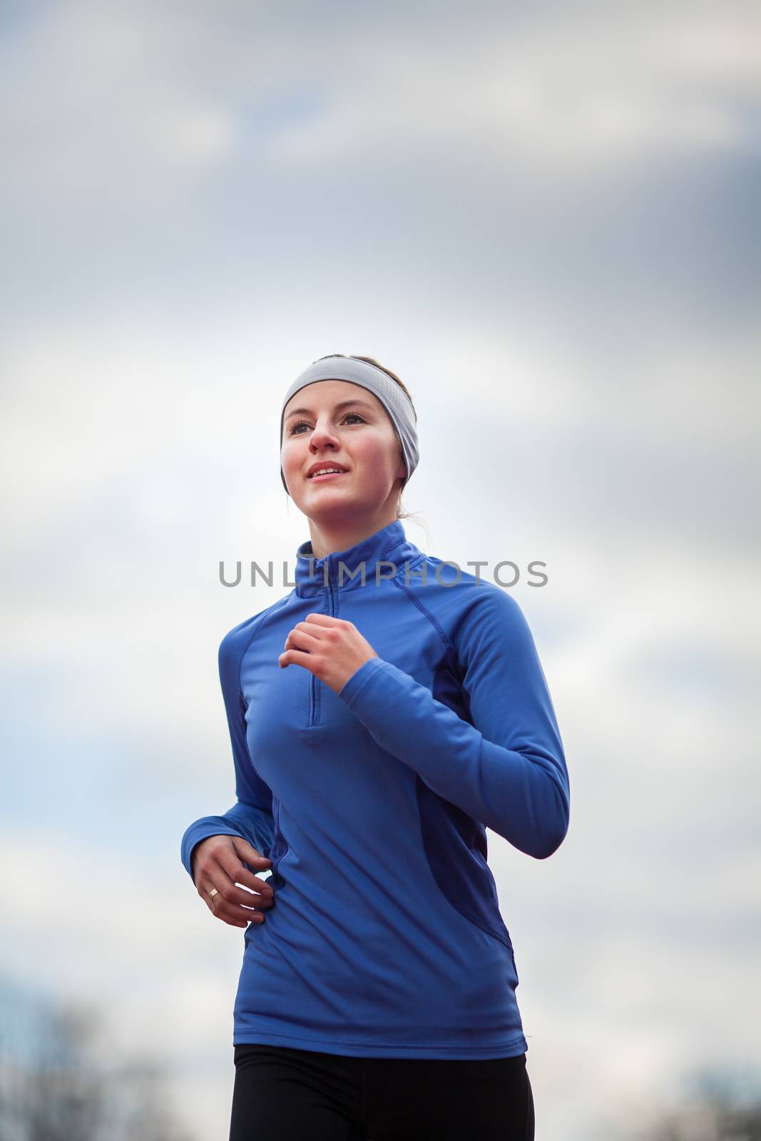 Portrait of a woman running against against blue sky by viktor_cap