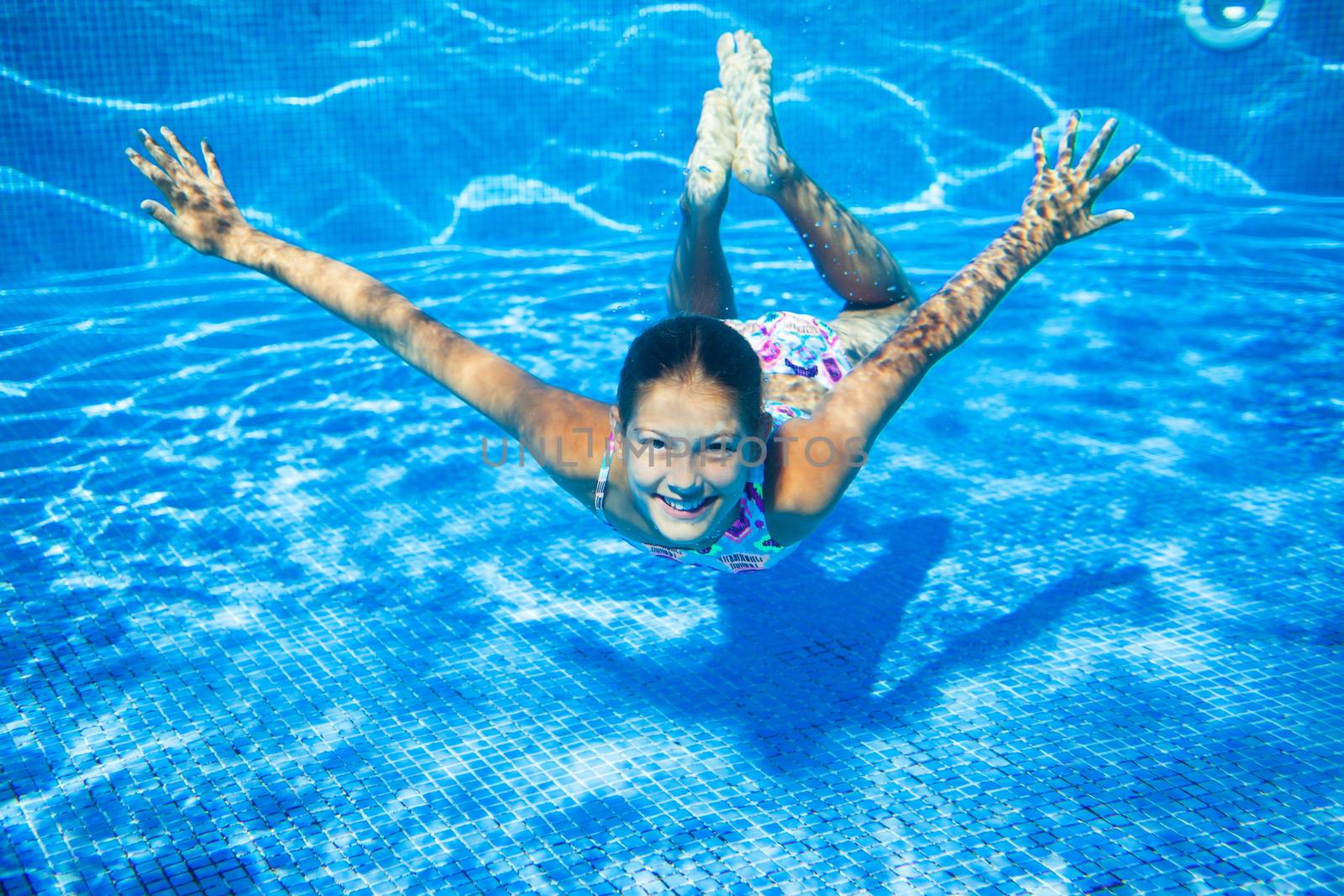 Underwater happy cute girl in swimming pool