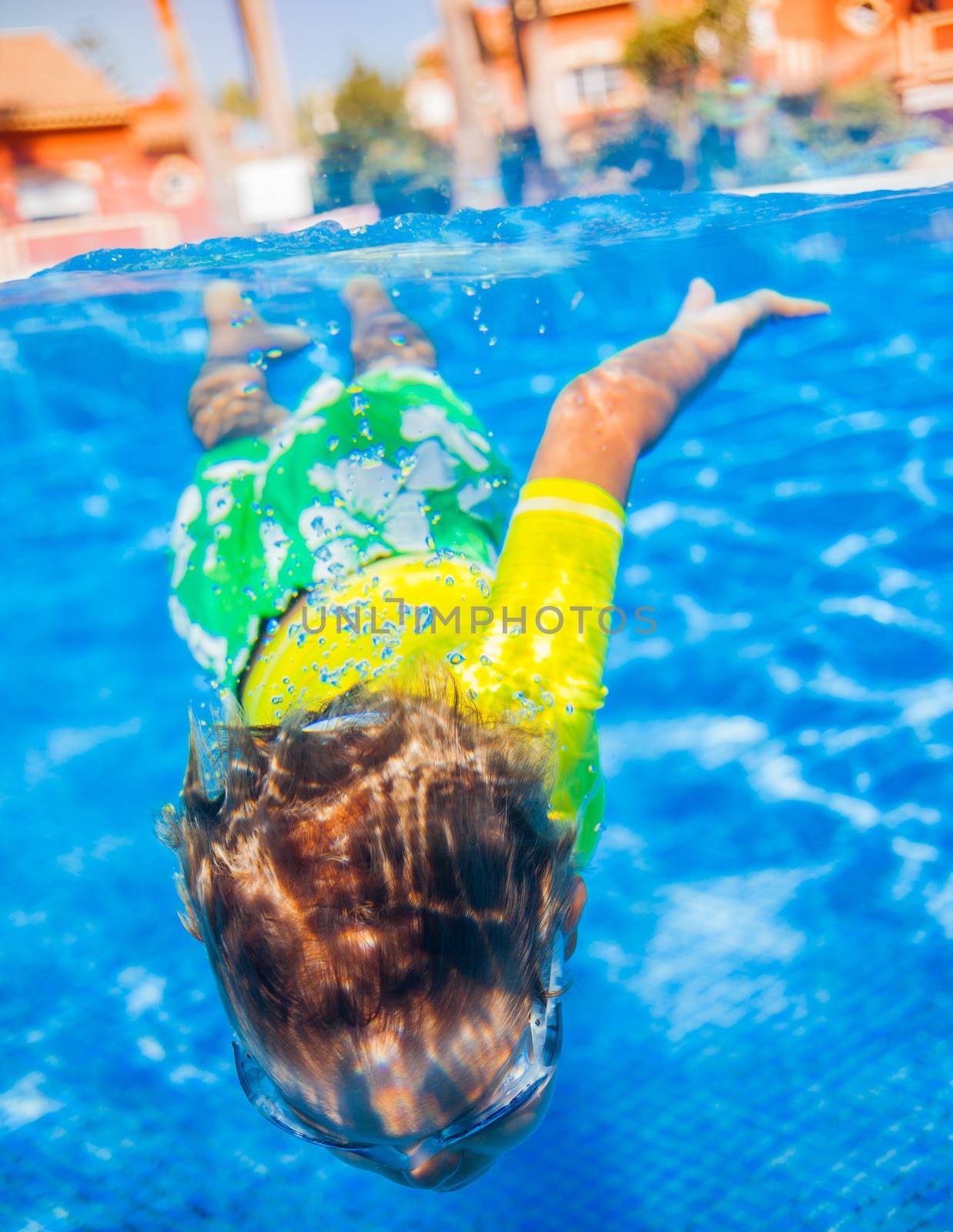 Underwater happy little boy in swimming pool