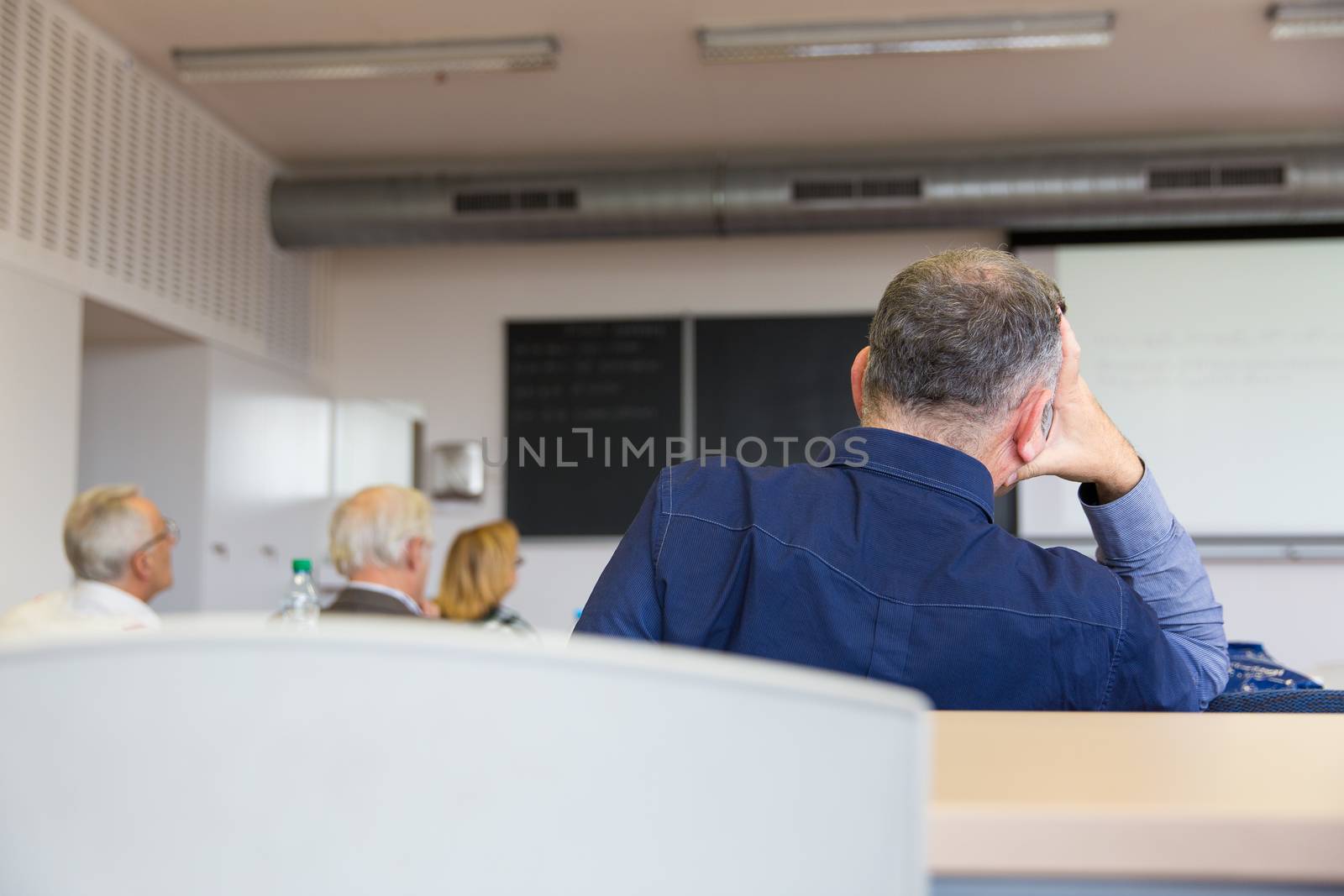 Elderly people are sitting in a classroom, learning something by viktor_cap