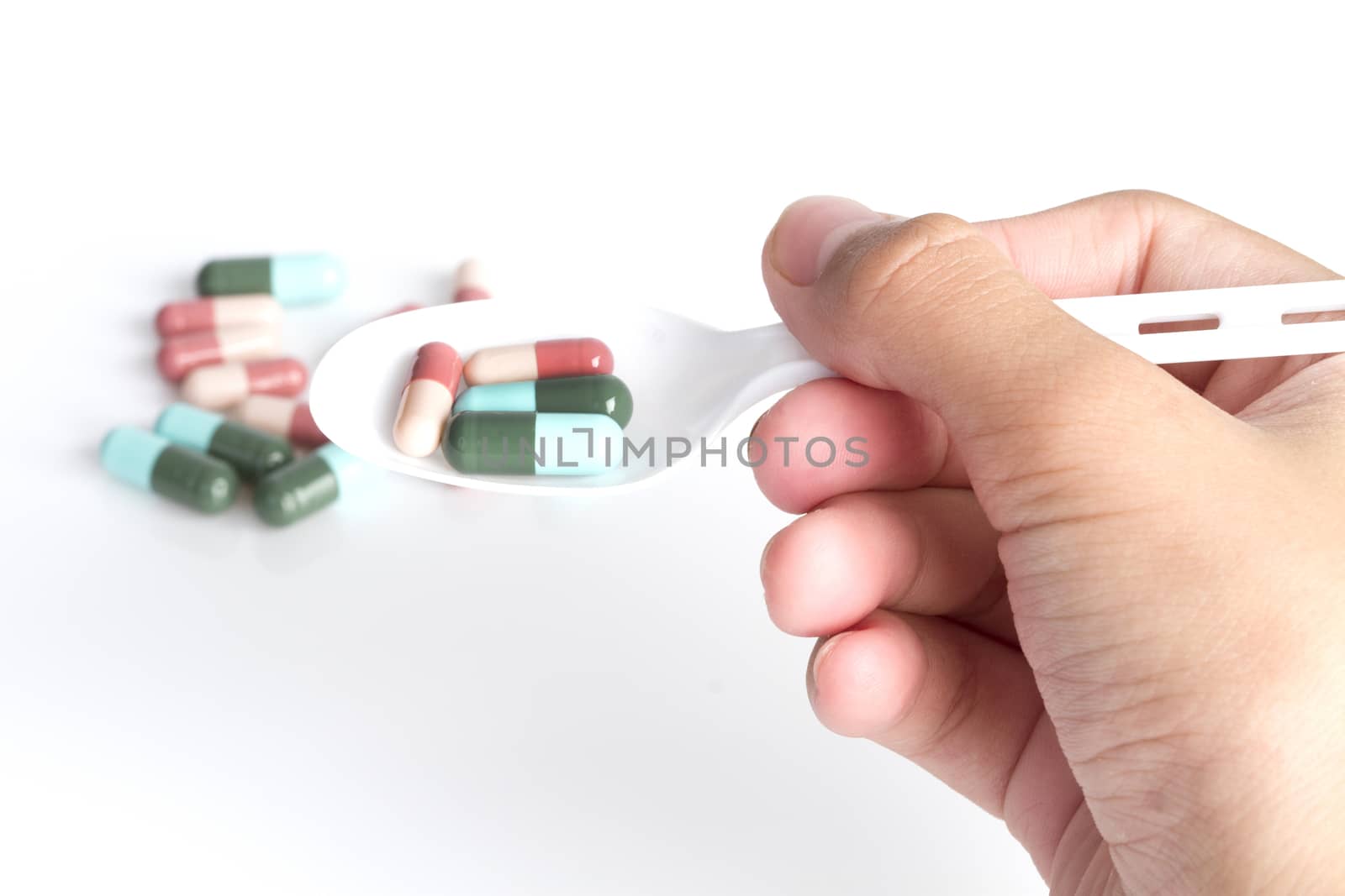 Spoon of pills isolated on white