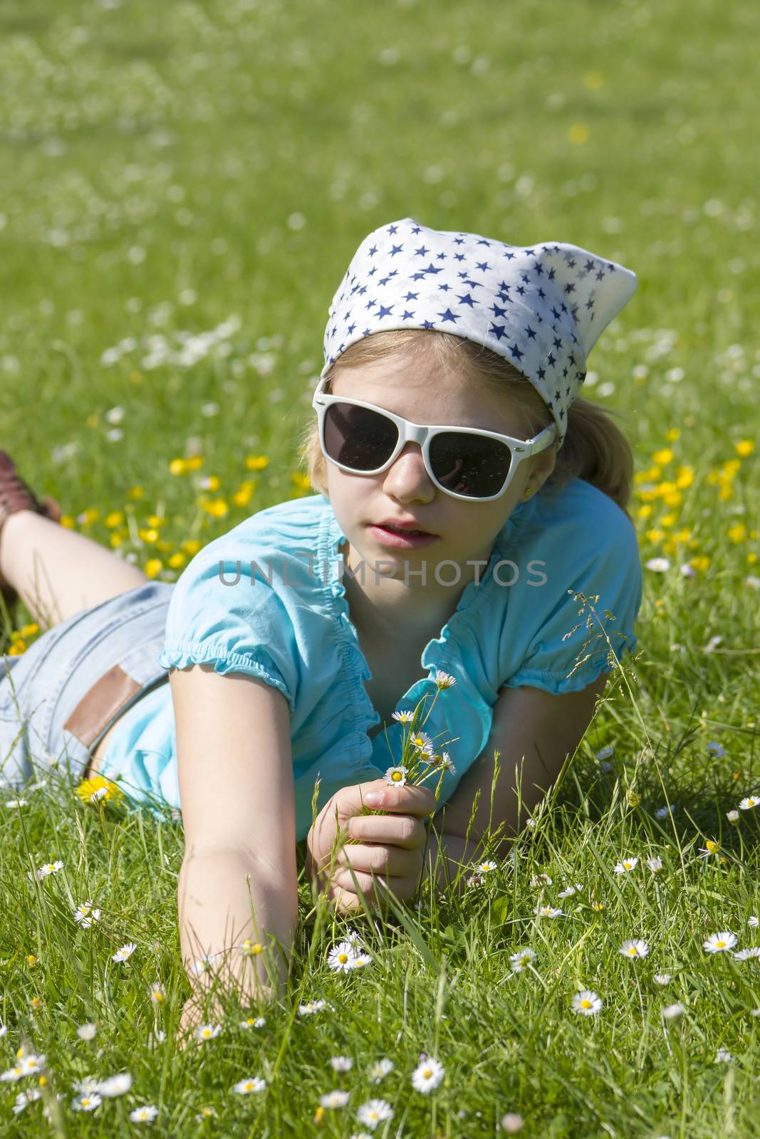 little girl lying on grass by miradrozdowski