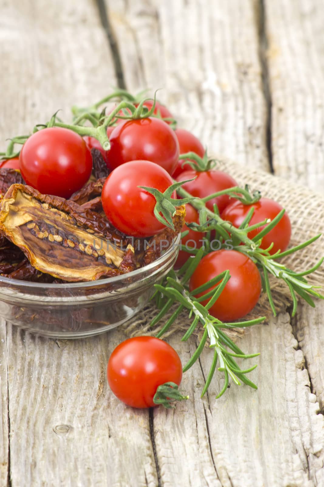 fresh and dried tomatoes on wooden background