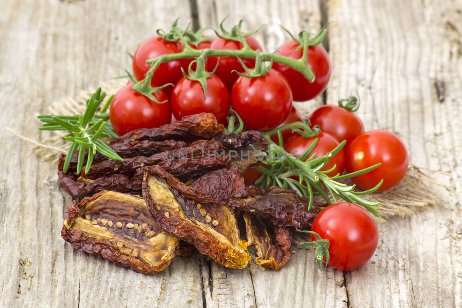 fresh and dried tomatoes on wooden background by miradrozdowski