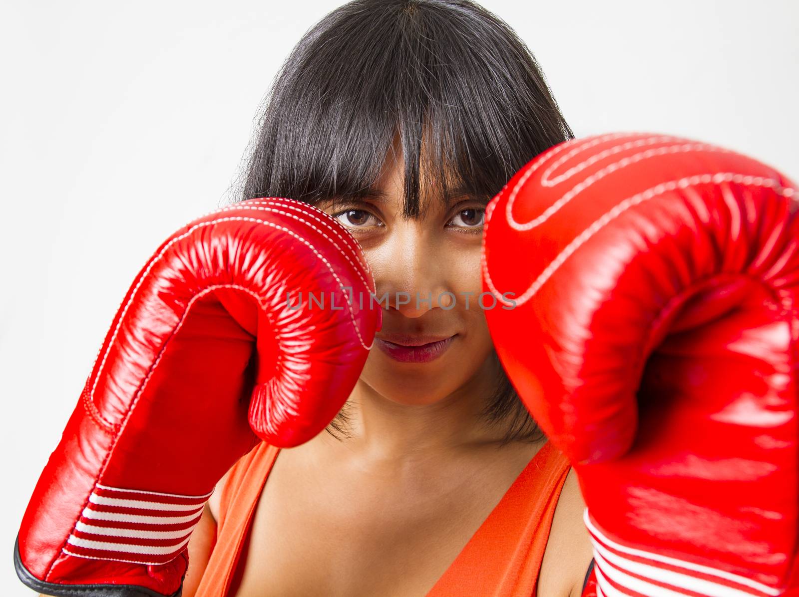 Young asian woman protecting her face with red boxing glove