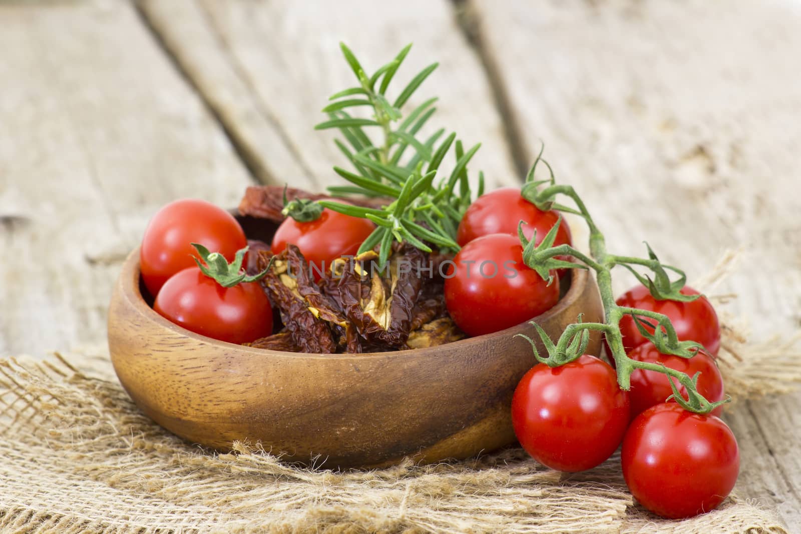 fresh and dried tomatoes on wooden background