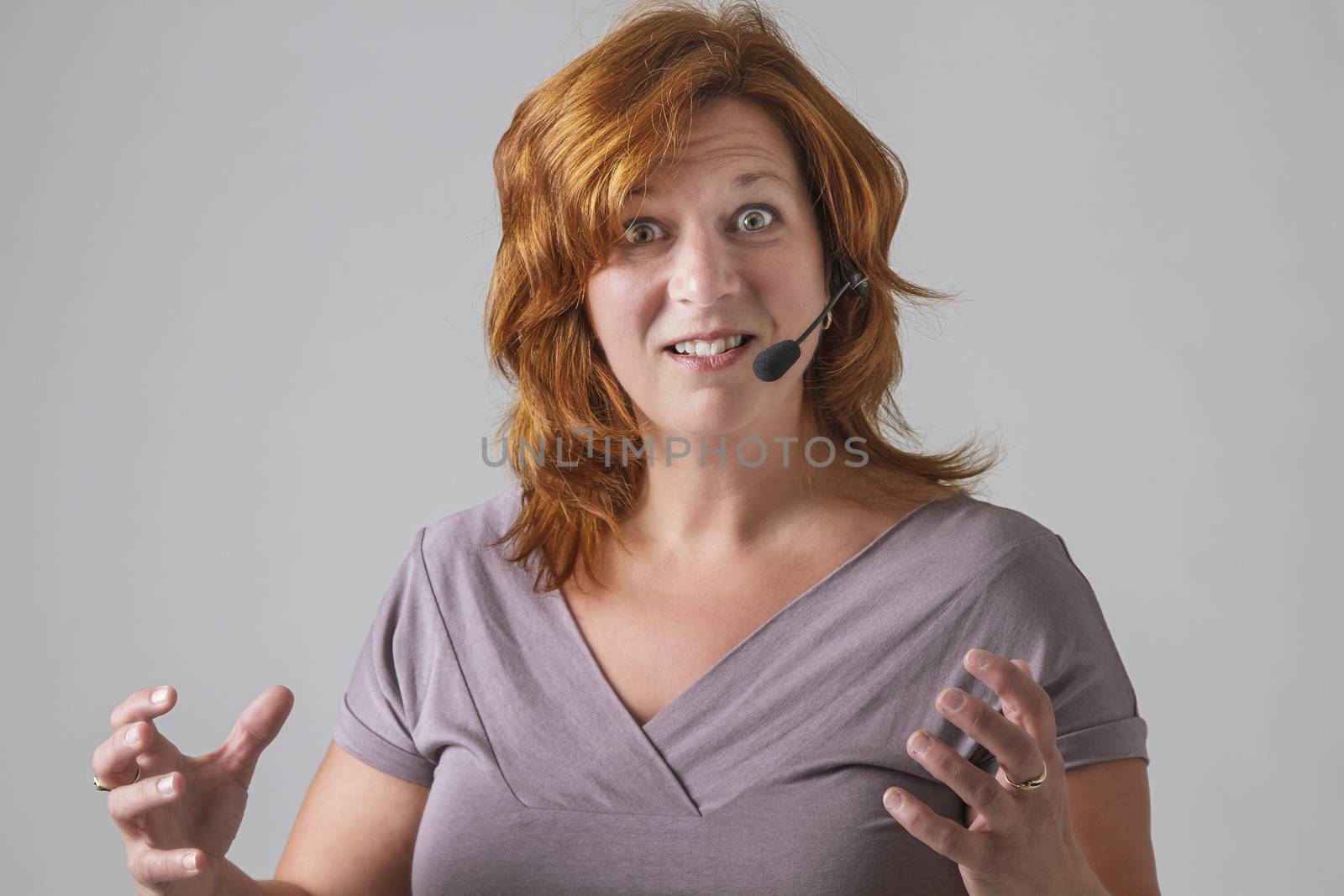 red hair female phone agent with headset with angry expression