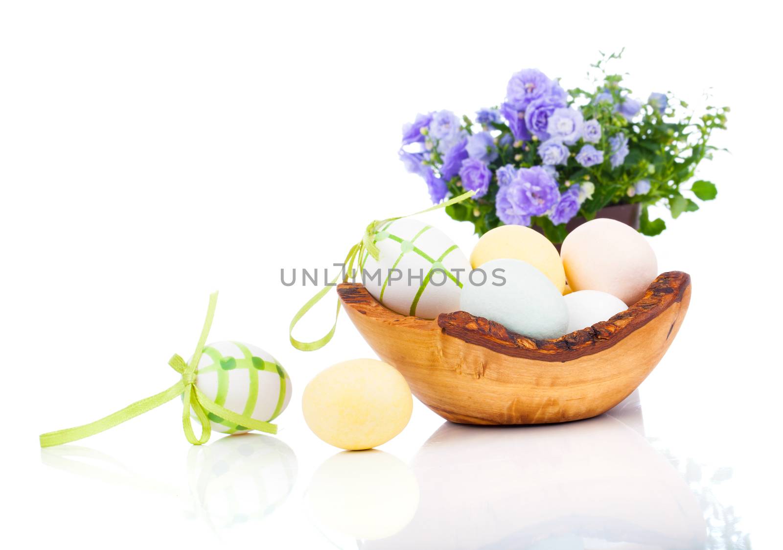 Easter eggs in wooden bowl, isolated on white background