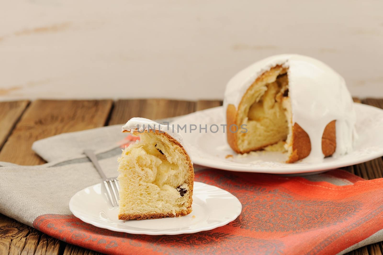 Kulich, traditional Russian Easter cake with icing, cut, on wooden background horizontal with space