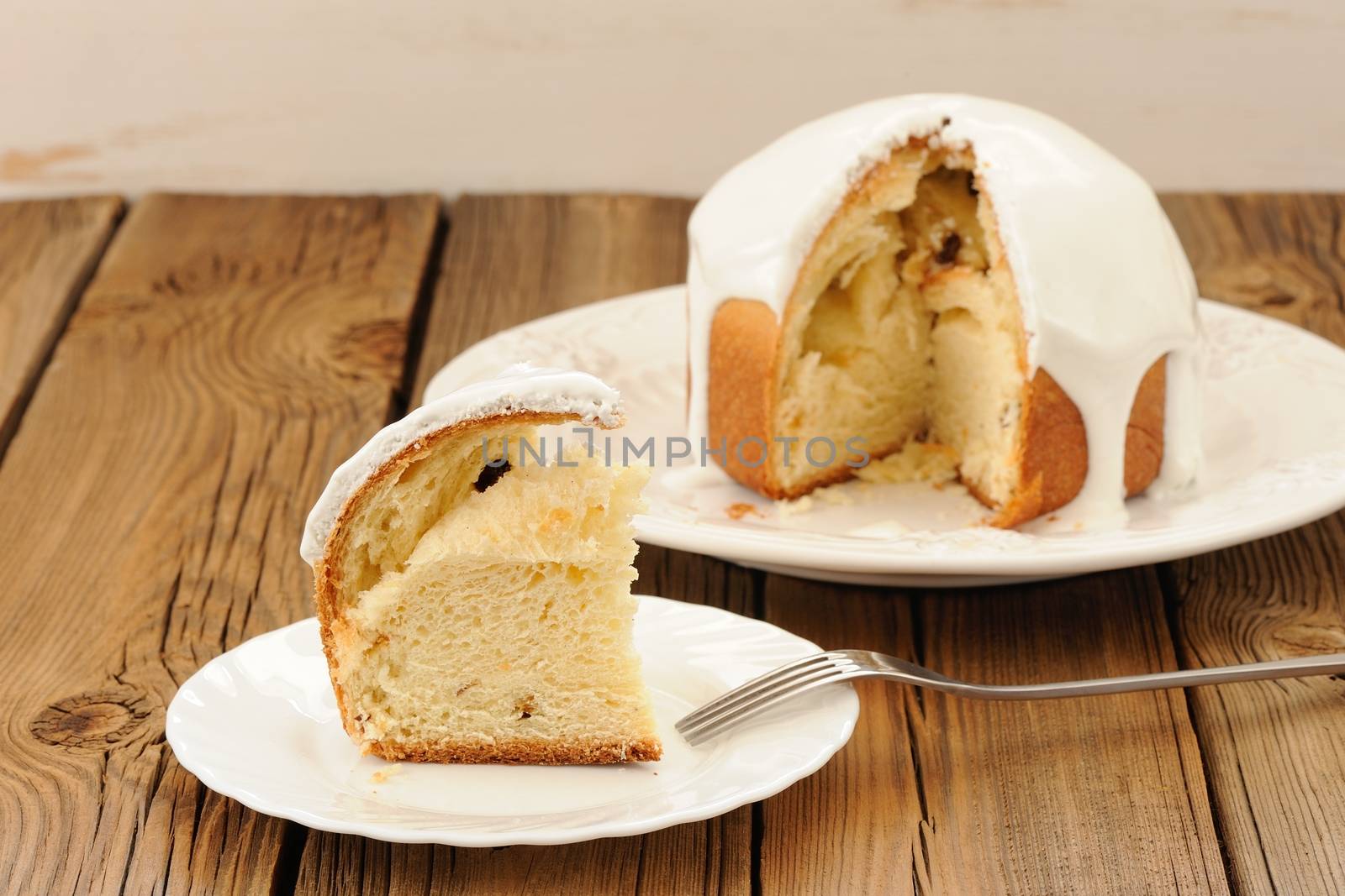 Kulich, traditional Russian Easter cake with icing, cut, on wood by Borodin
