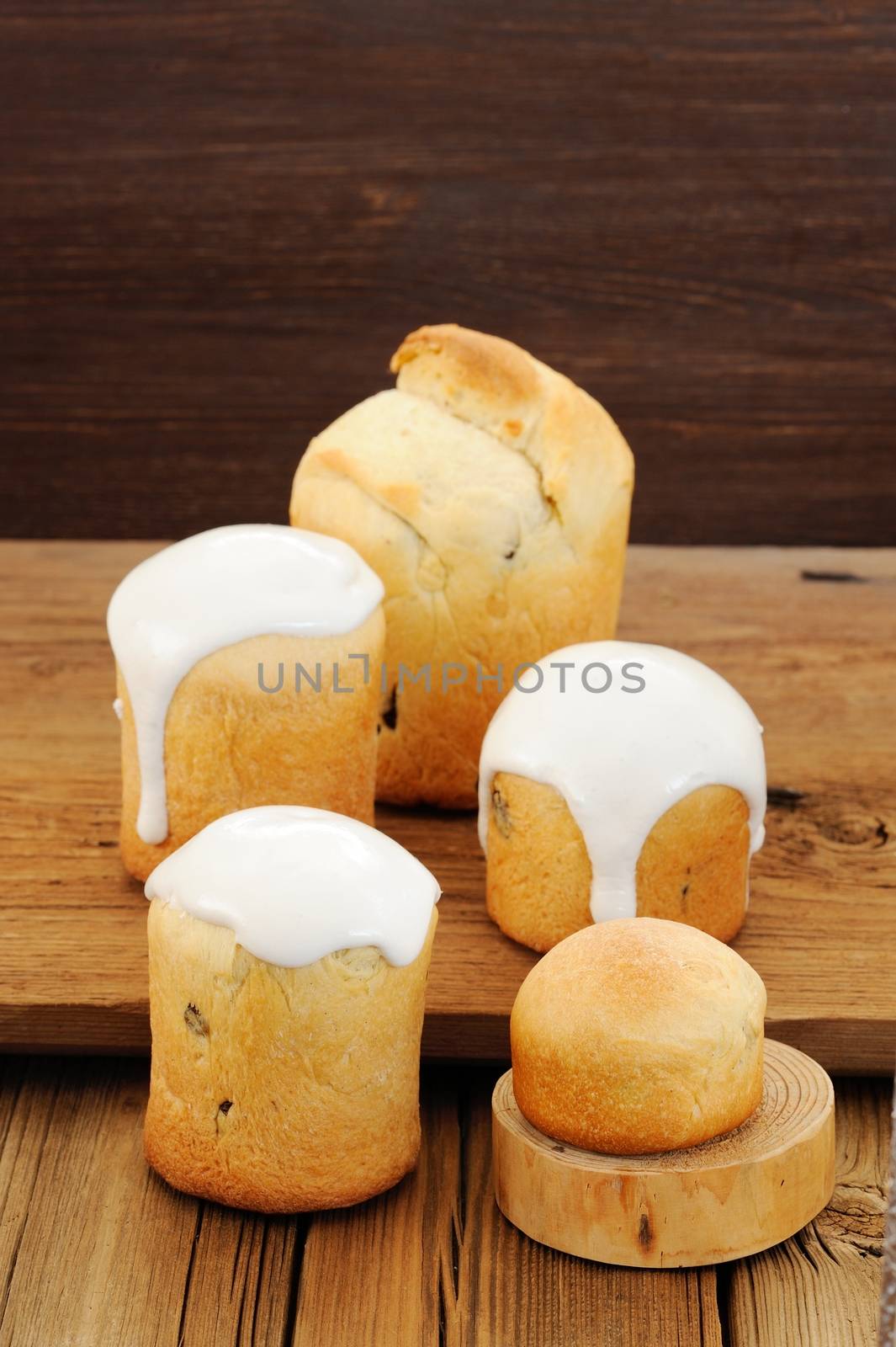 Kulichi, traditional Russian Easter cake with icing on wooden background vertical with space