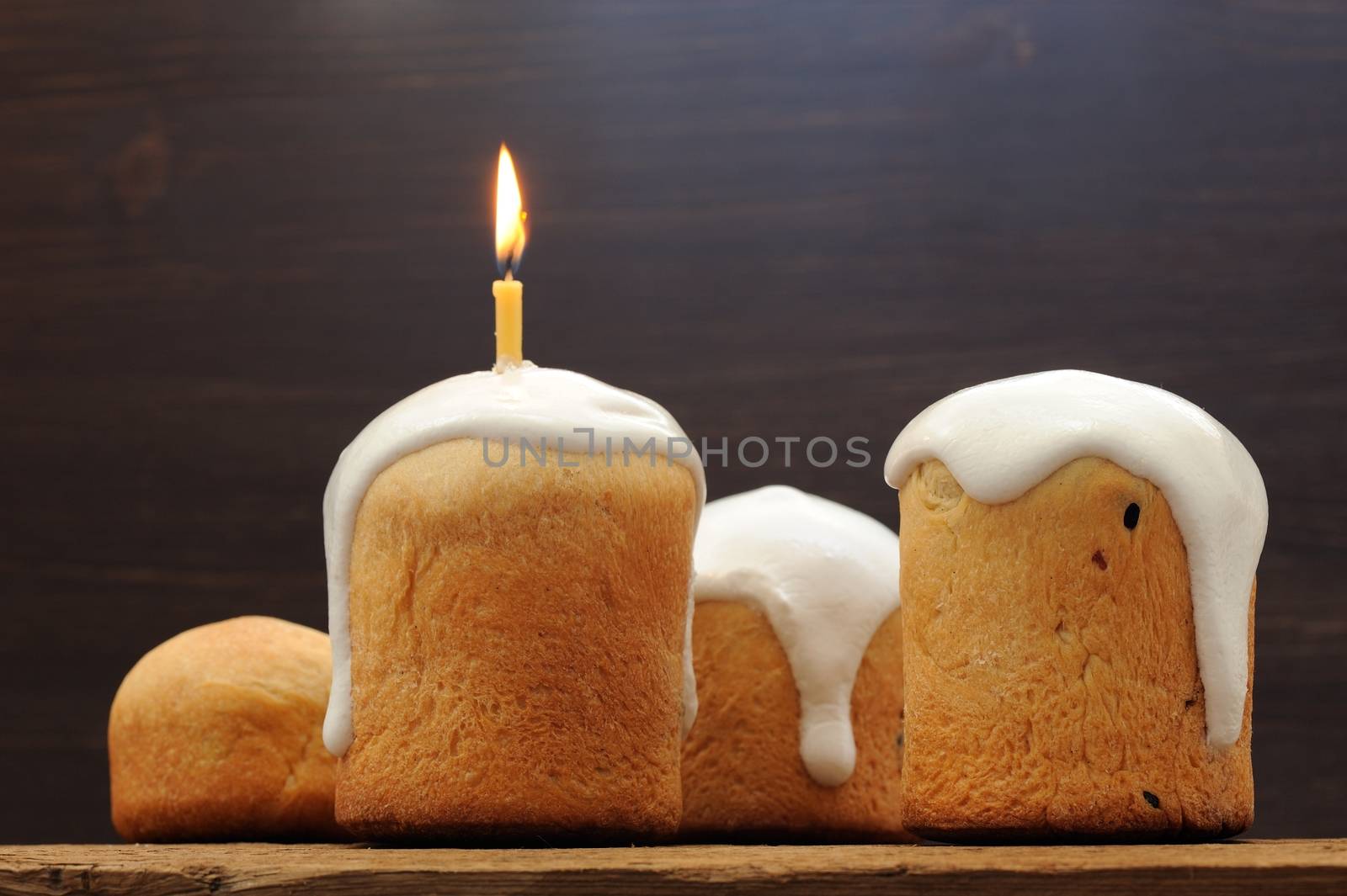 Kulichi, traditional Russian Easter cake with icing and candle o by Borodin