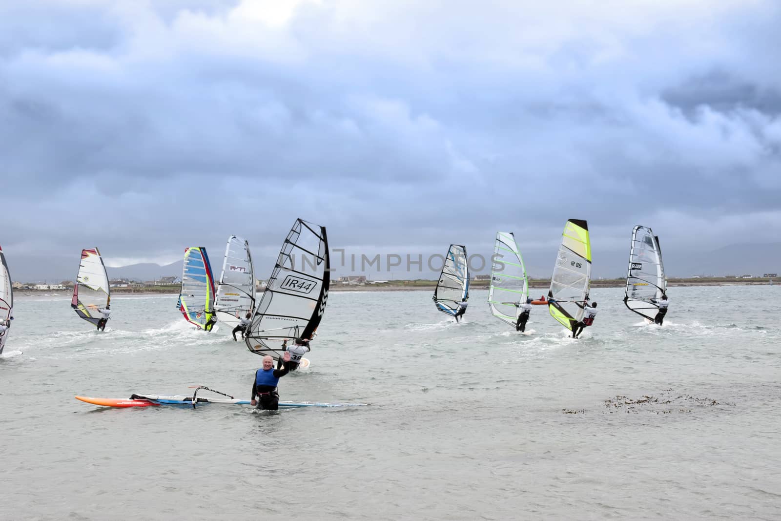 waving wind surfer racing in the Atlantic storm winds by morrbyte