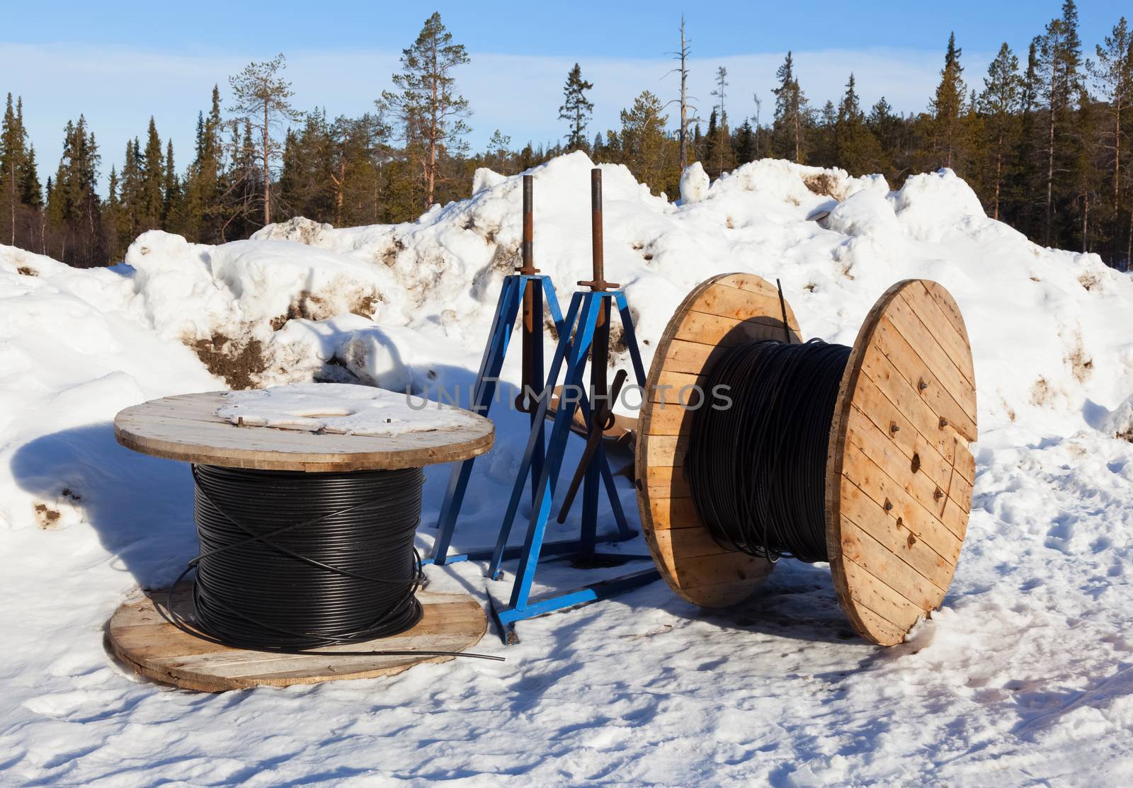 Cable drums prepared for installation in northern snowy forest