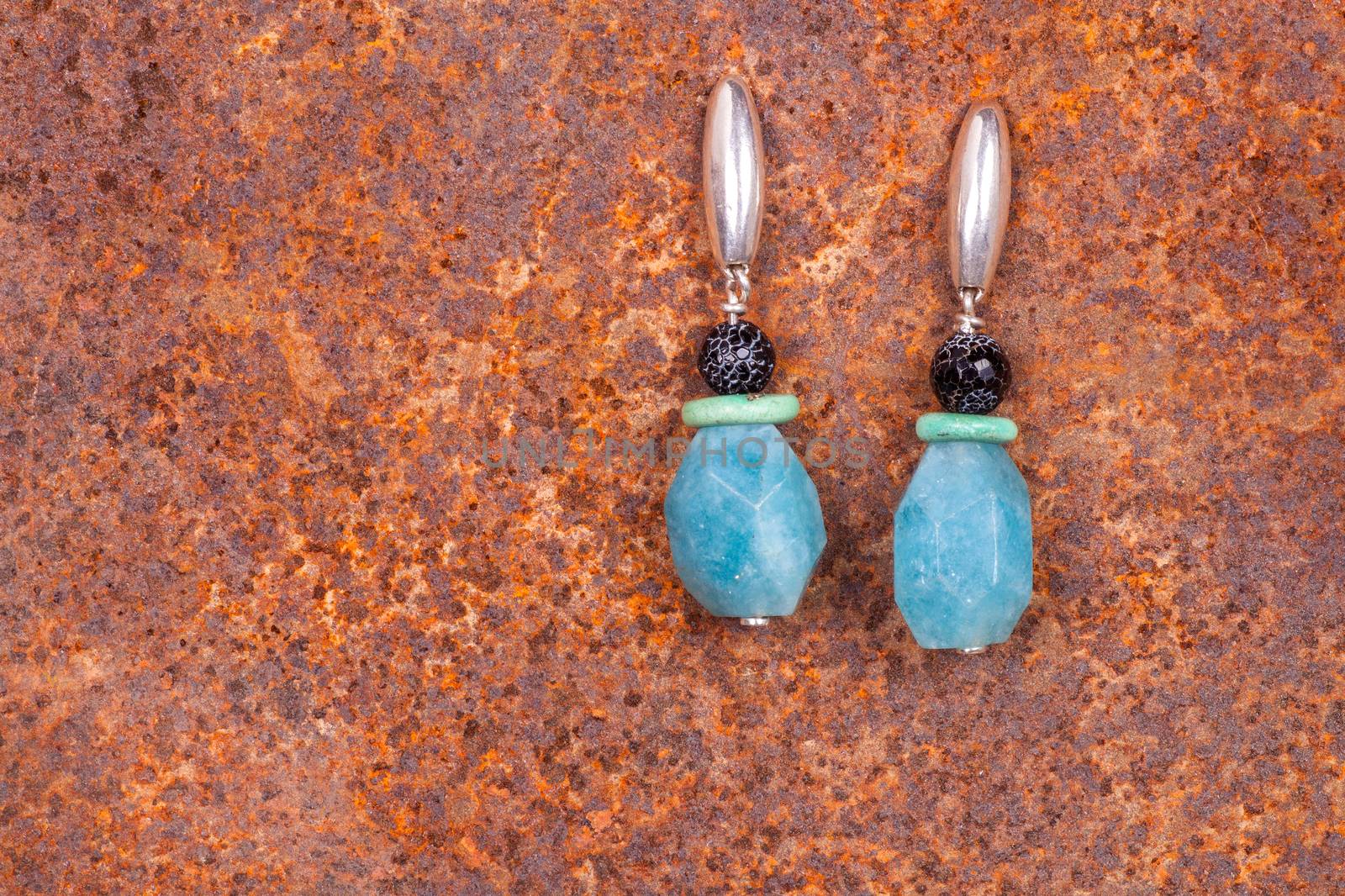 Close up of chalcedony earrings on rusty iron, manufactured by Ornella Salamone