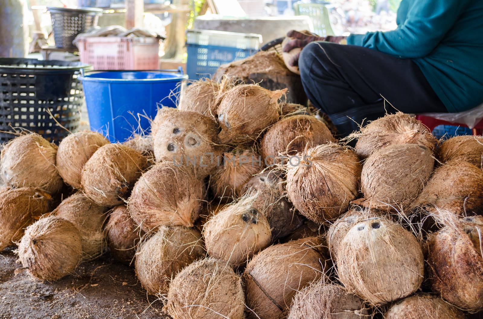 Farmer cutting coconut shell for processing agricultural products at a small factory in Thailand.