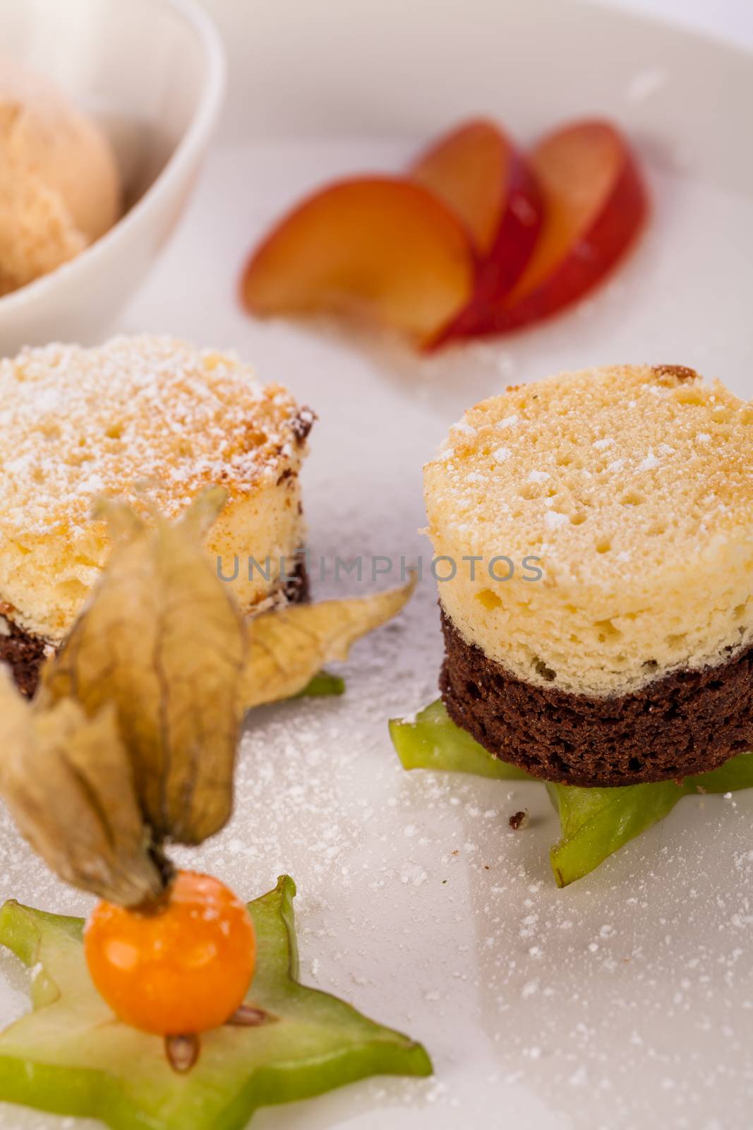 Gourmet coffee and chocolate blanc mange with a colourful ripe Cape gooseberry and sliced carambola or star fruit served on a plain white plate