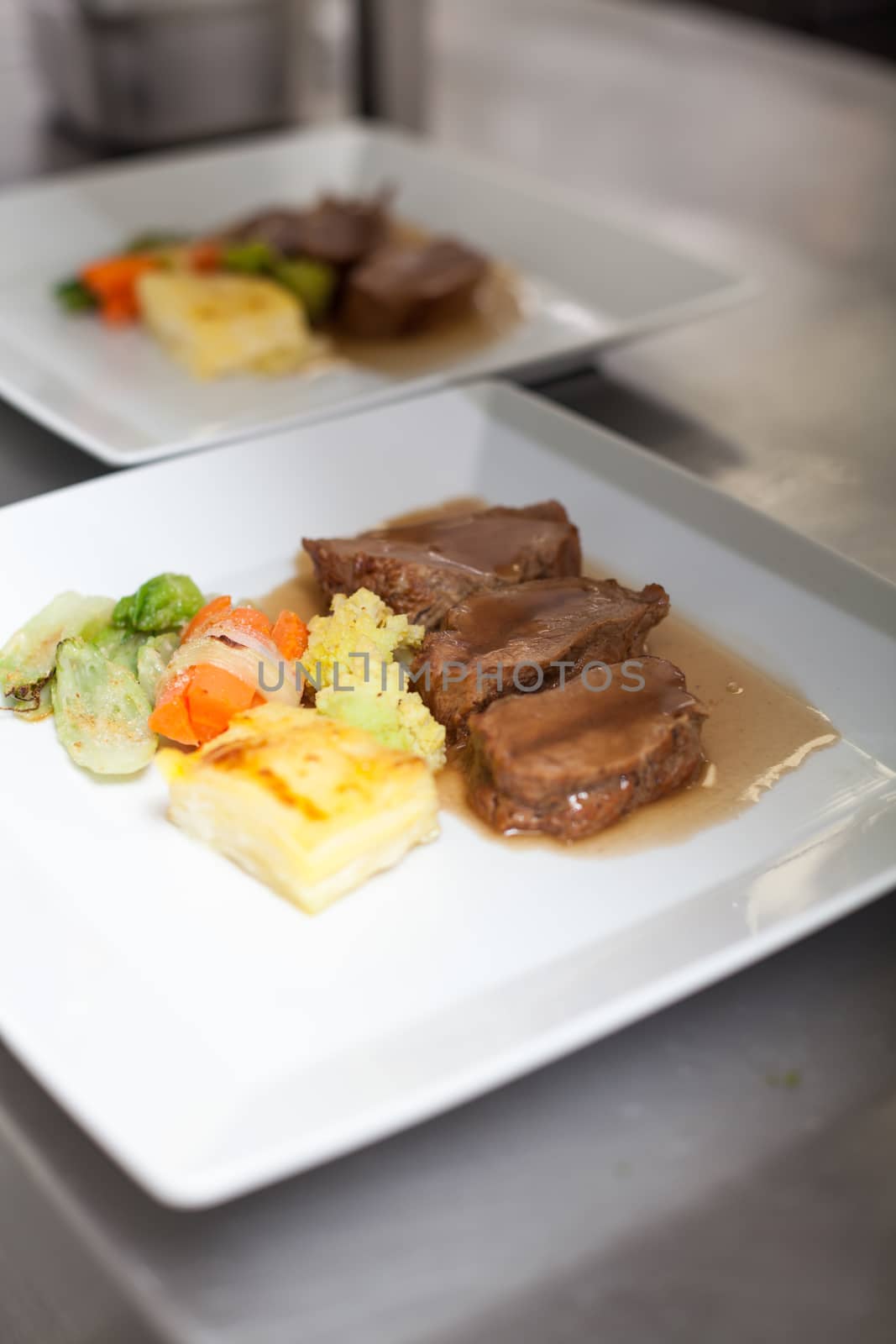 Chef plating up food in a restaurant by juniart