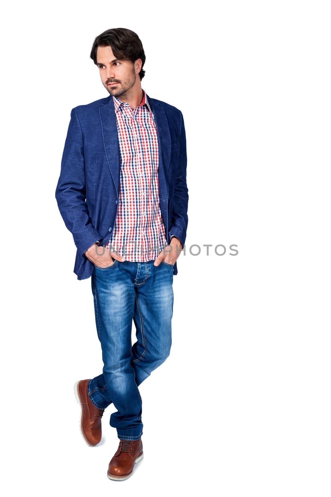 Handsome smiling man in stylish leisurewear approaching the camera in a relaxed posture with his hand in his pocket, isolated on white