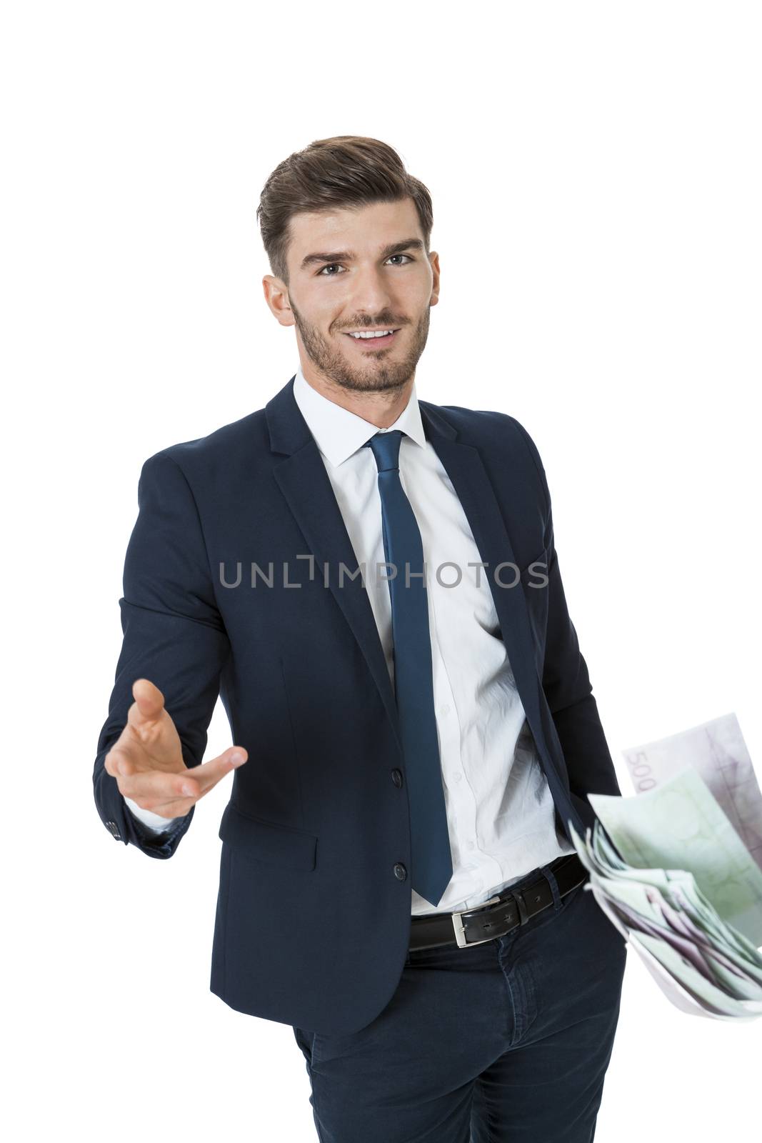 Wealthy successful stylish young businessman burning money from a handful of euro banknotes with a happy smile showing off his affluence, isolated on white