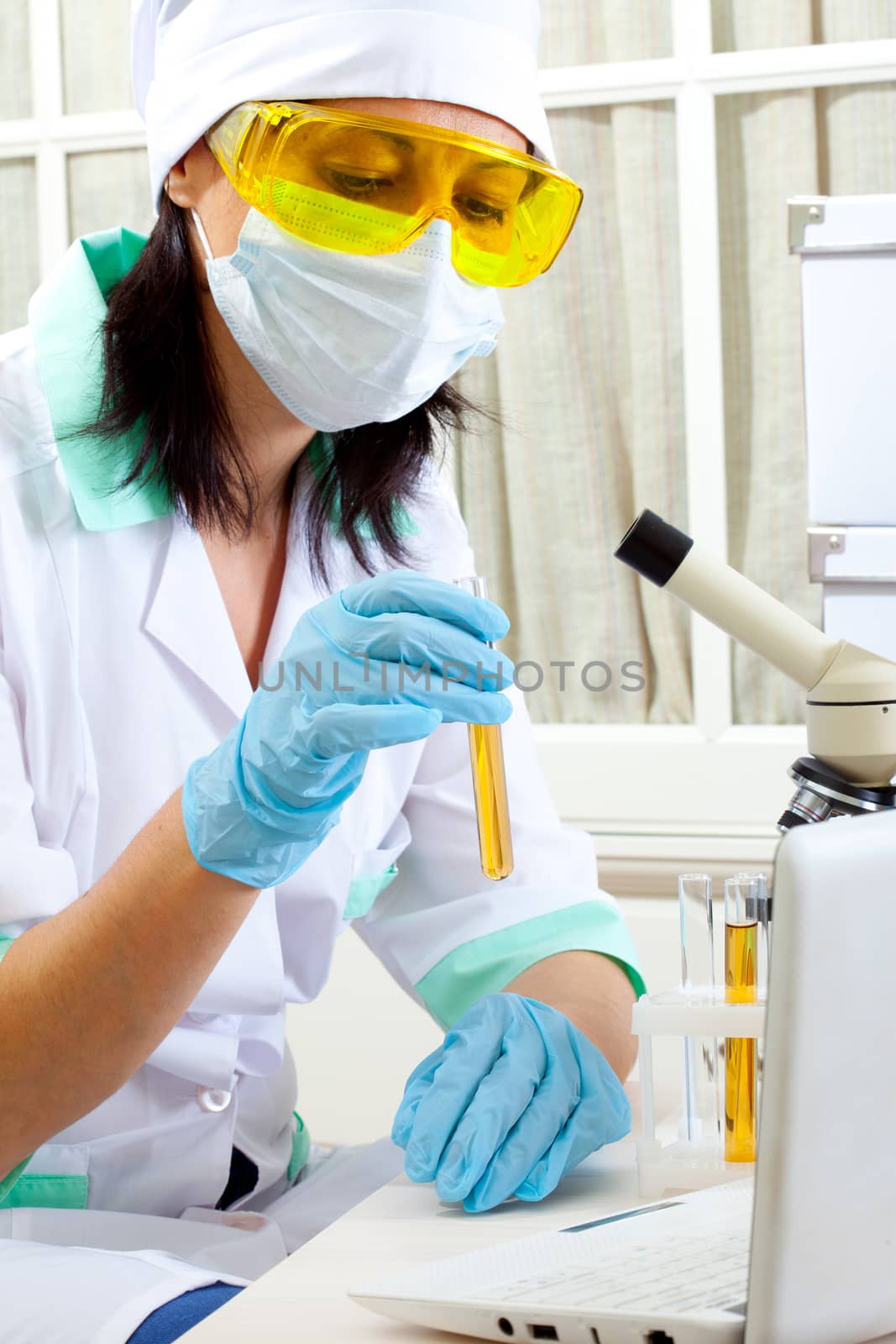 portrait of woman scientist in laboratory analyzing yellow liquid in test tube