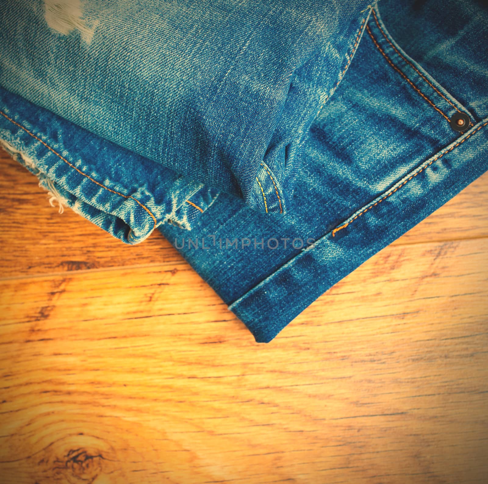 Lot of different blue jeans on the wooden shelf. instagram image style