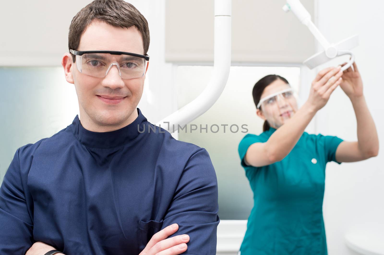 Dentist posing with arms crossed at dental clinic