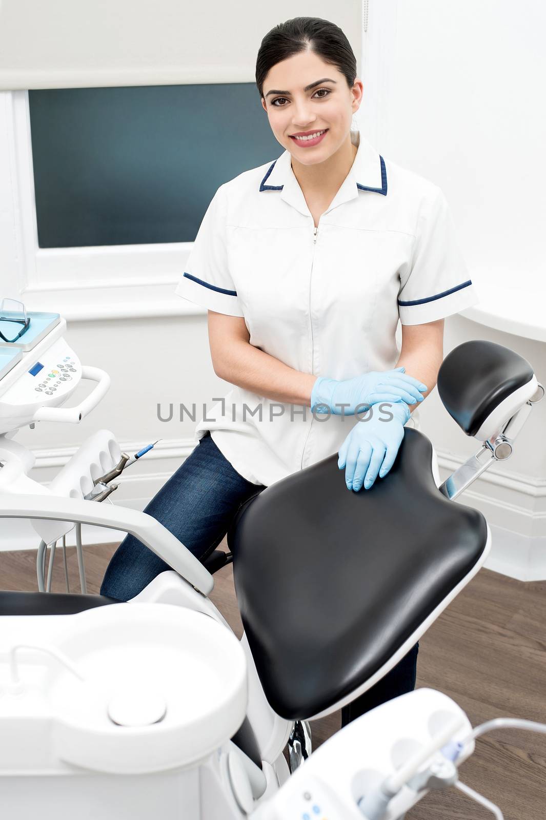 Female dental assistant standing beside chair