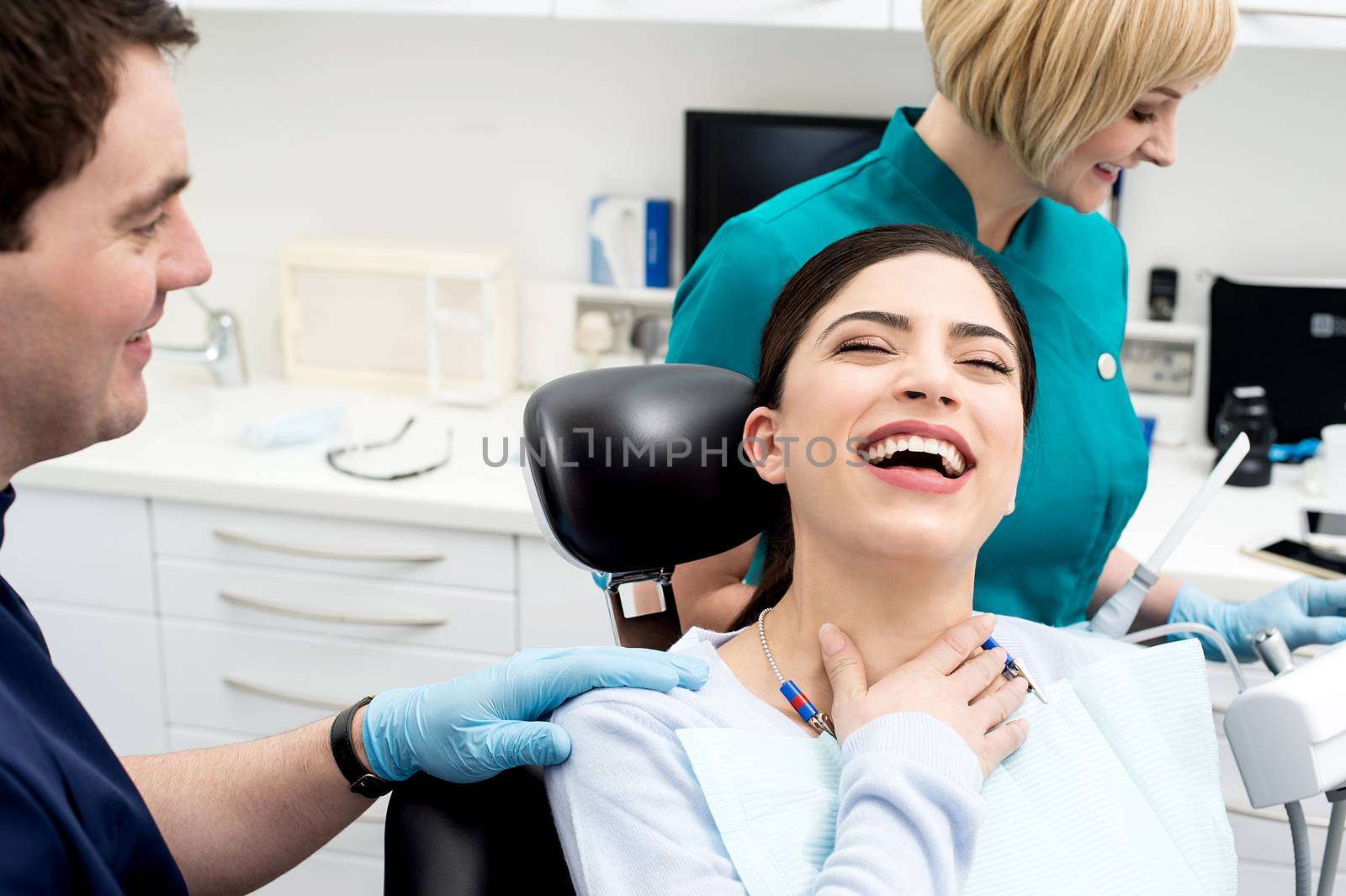 Friendly dentist at work with her assistant