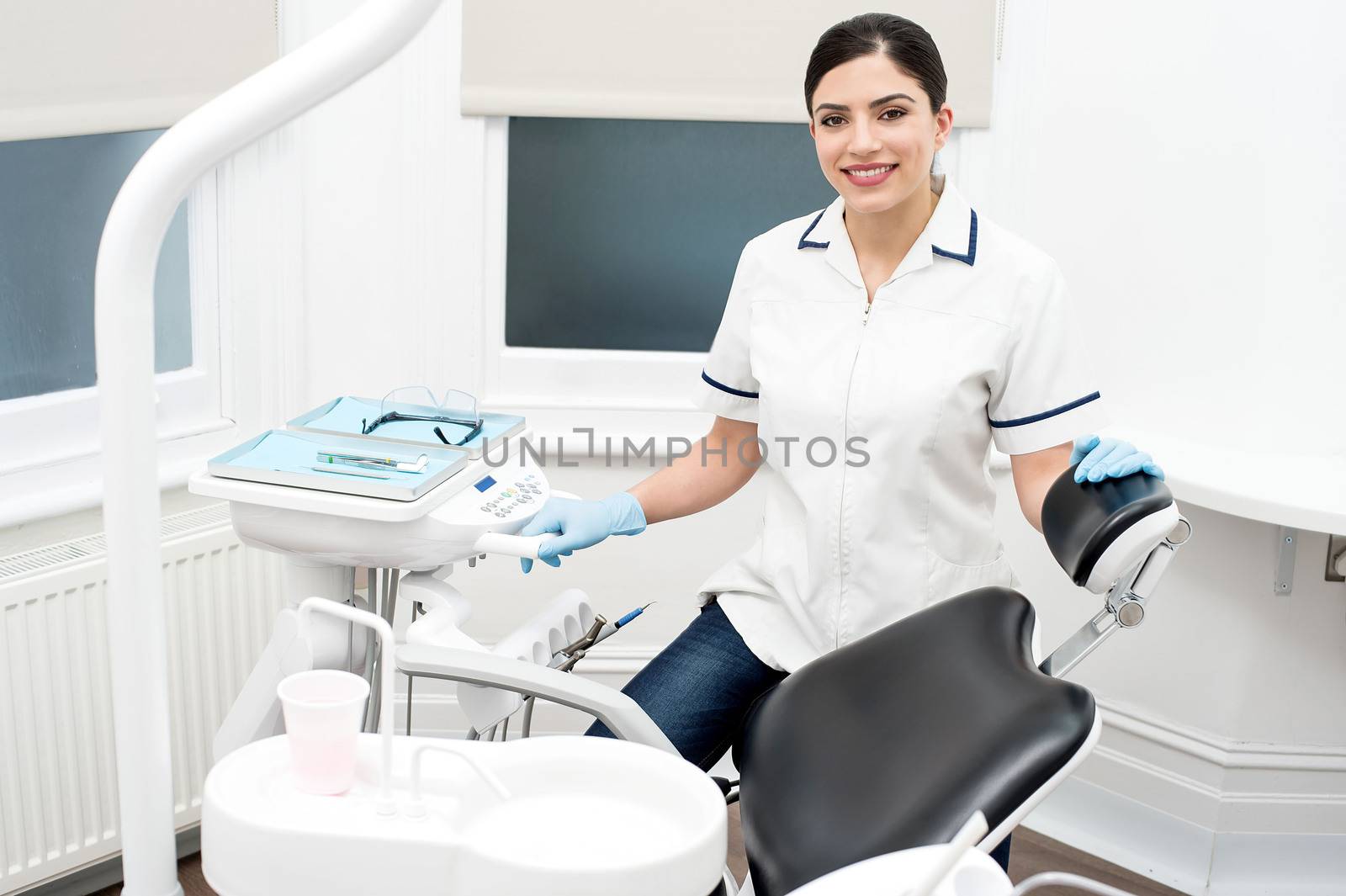Female dentist standing by dental chair at clinic