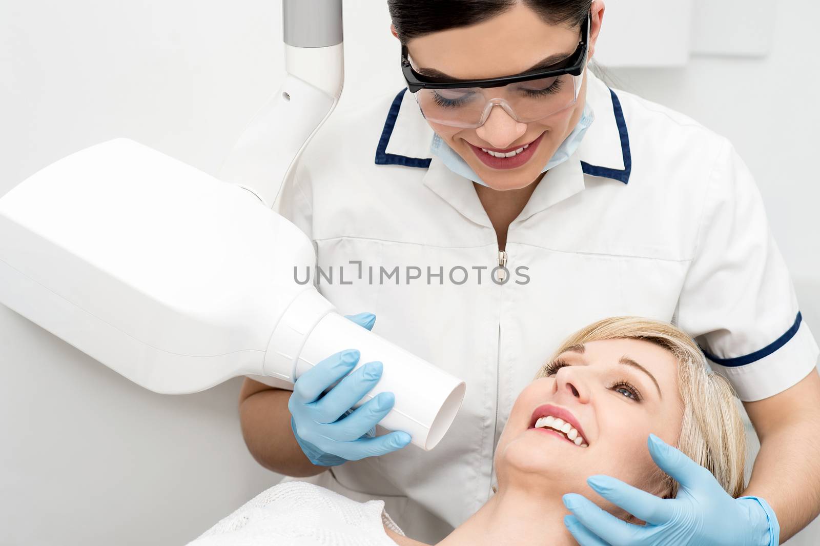 Female dentist using x-ray machine  by stockyimages