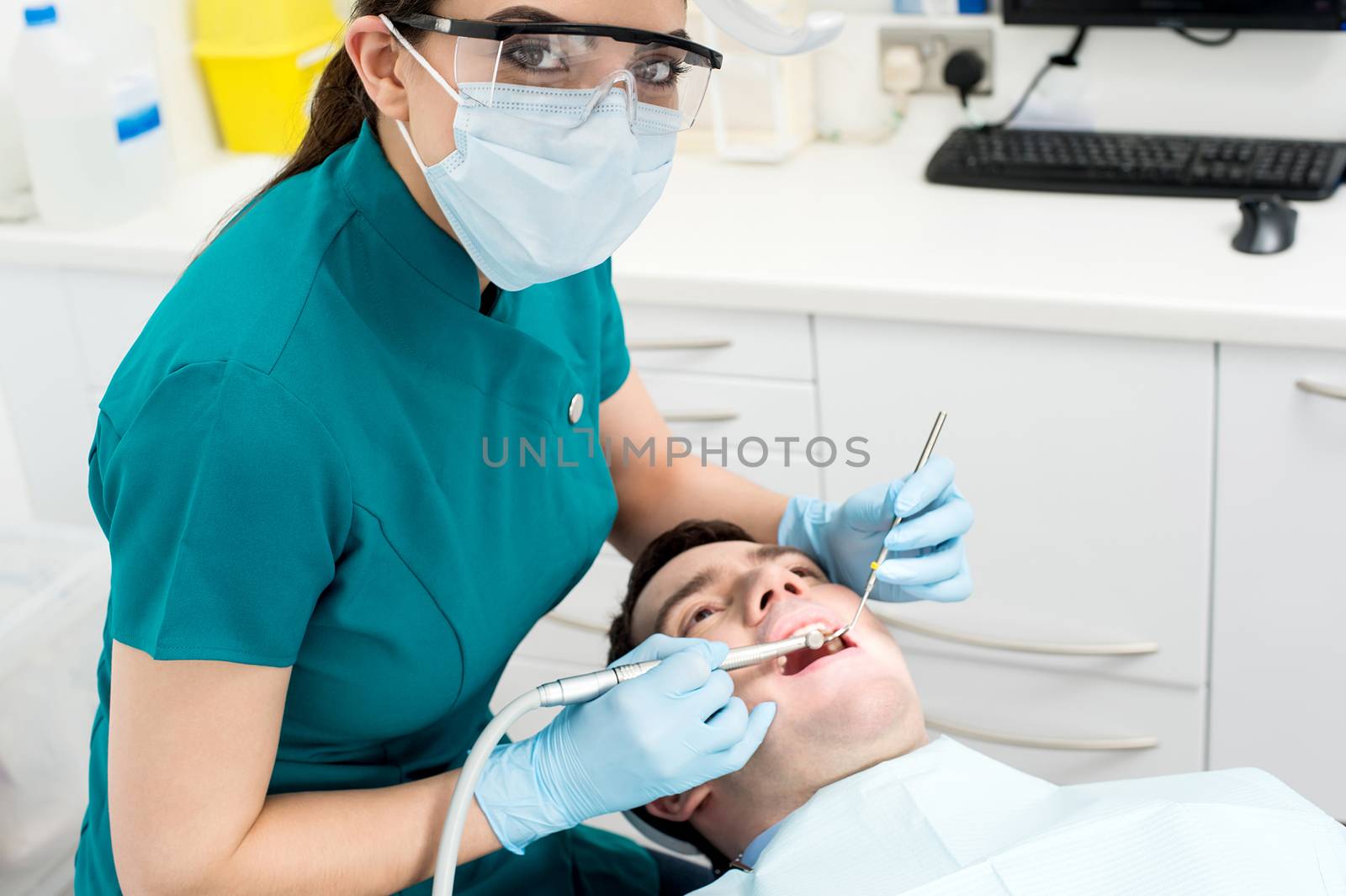 Dentist examining mouth of patient by stockyimages
