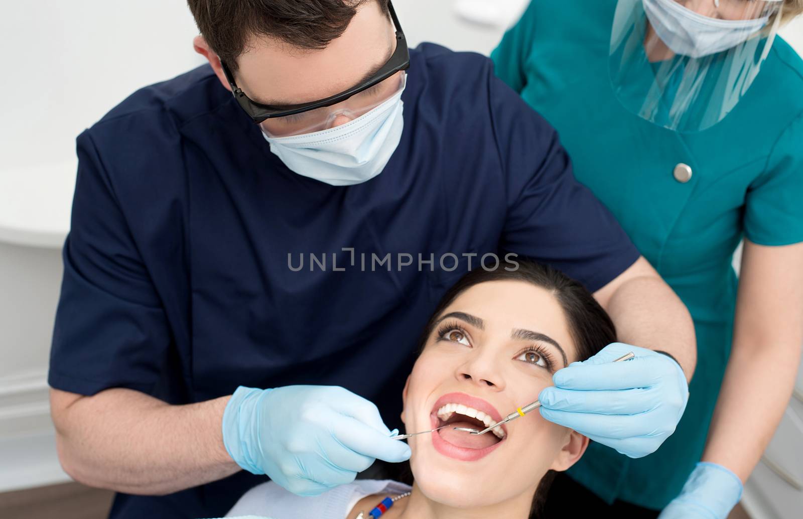Dentist examining female patient mouth with dental mirror 