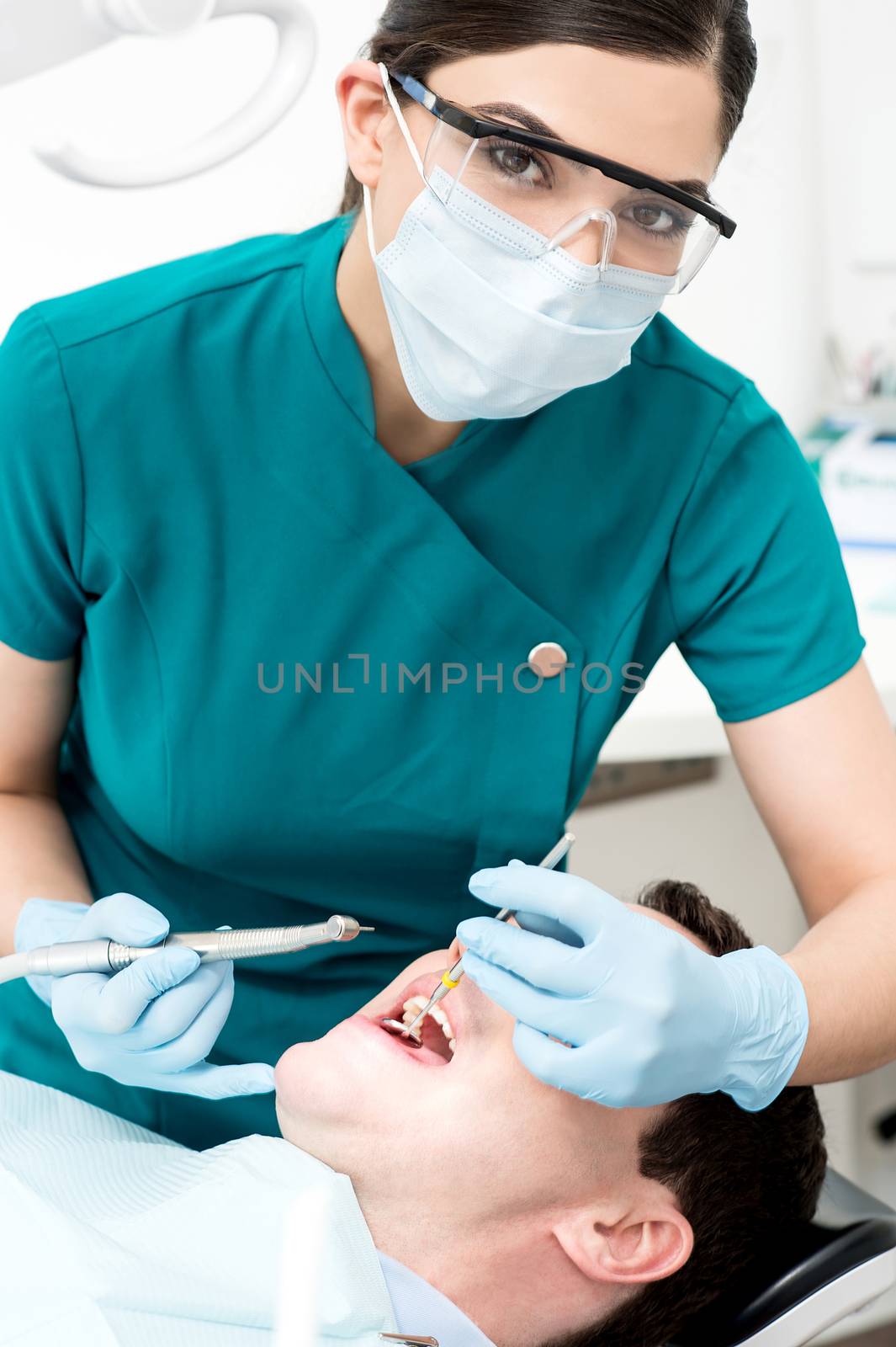 Female dentist examines a patient by stockyimages