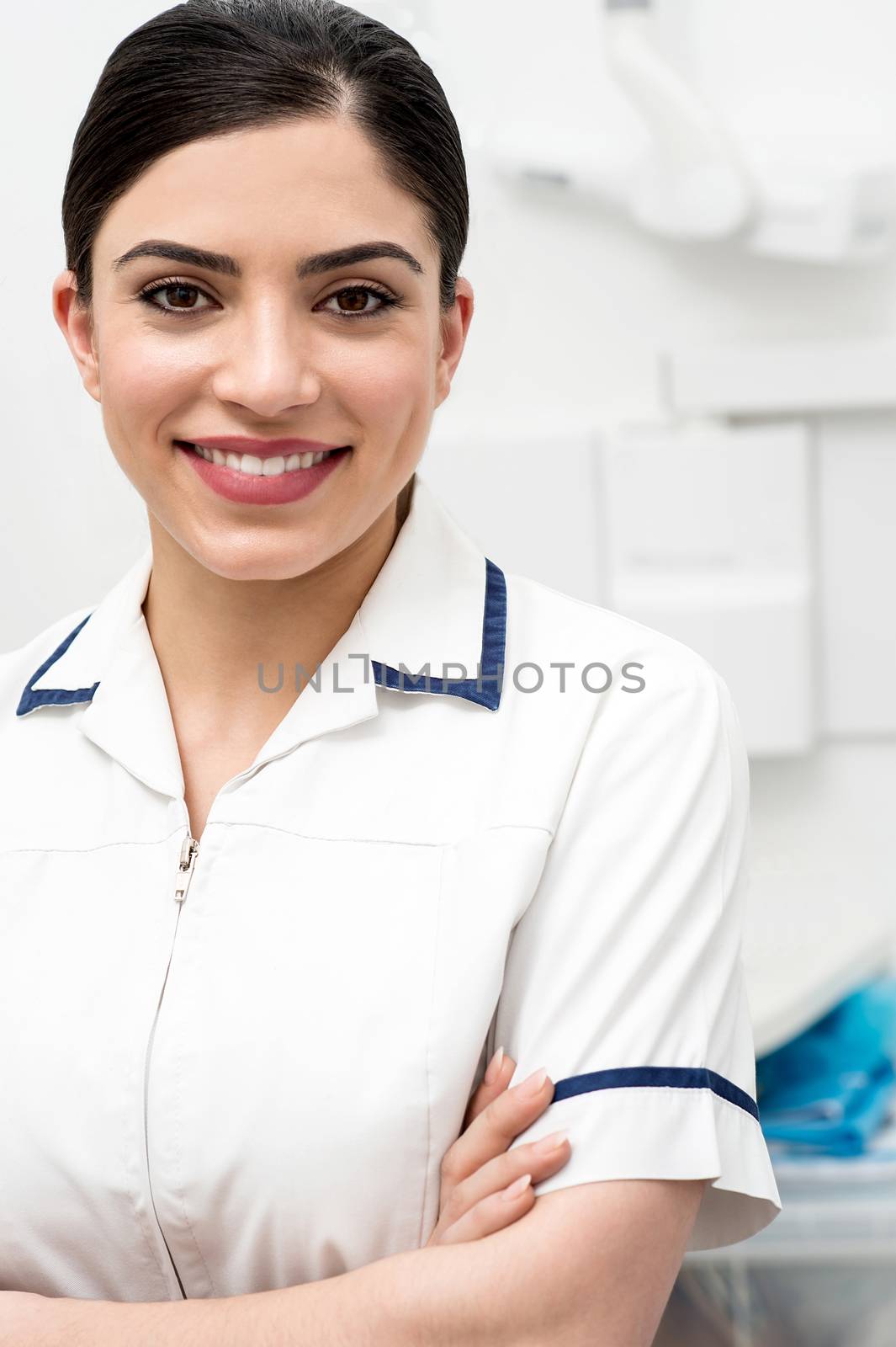 Confident female dental assistant posing in clinic