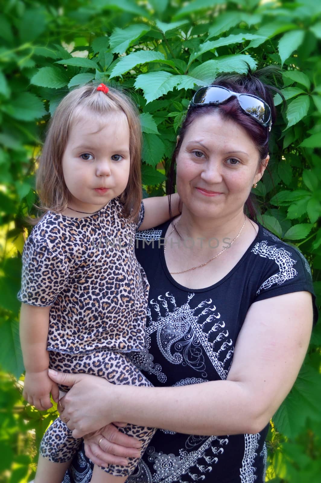 Grandmother with her granddaughter in her arms by mayboro