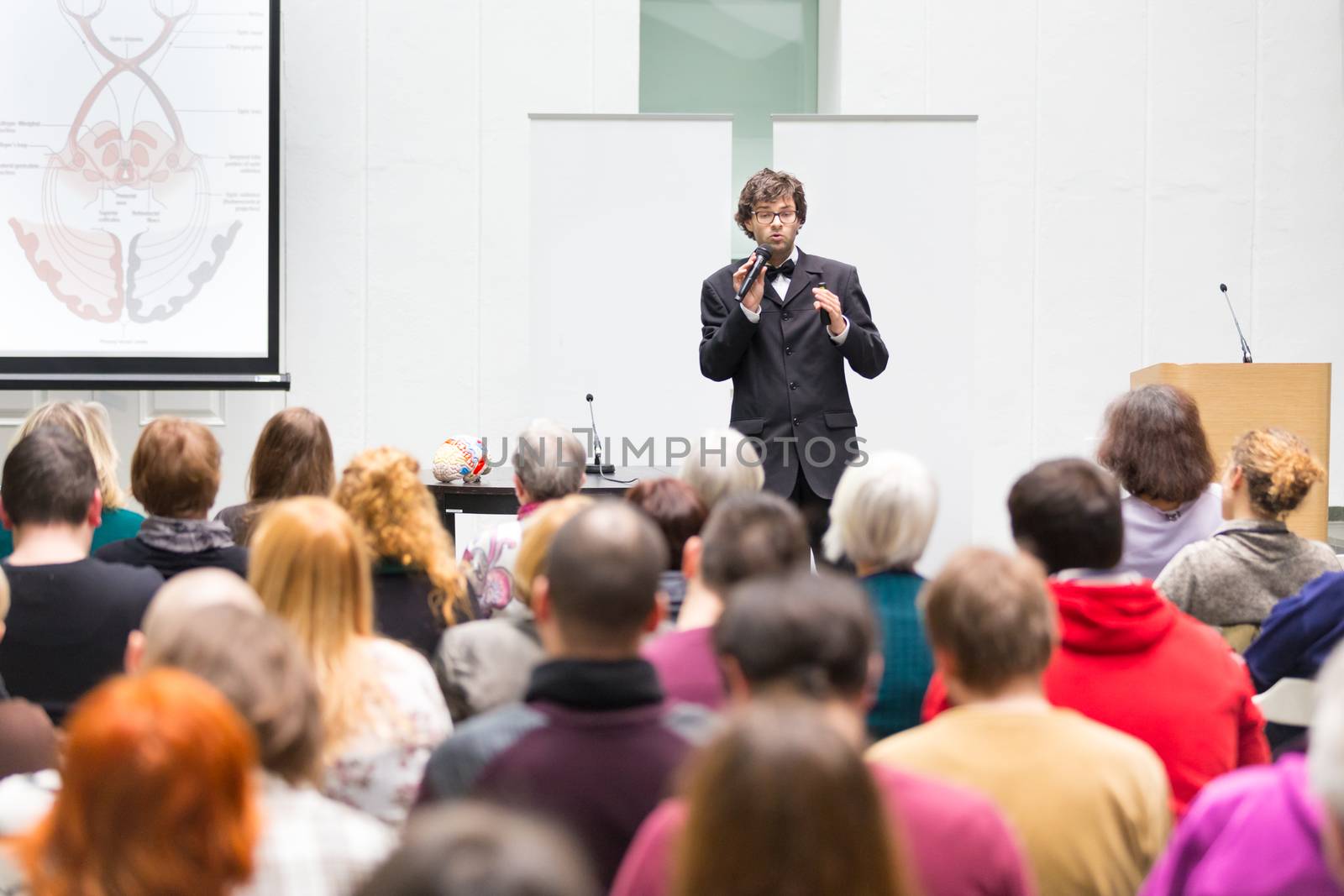 Speaker Giving a Talk at Business Meeting. Audience in the conference hall. Business and Entrepreneurship. Copy space on white board.